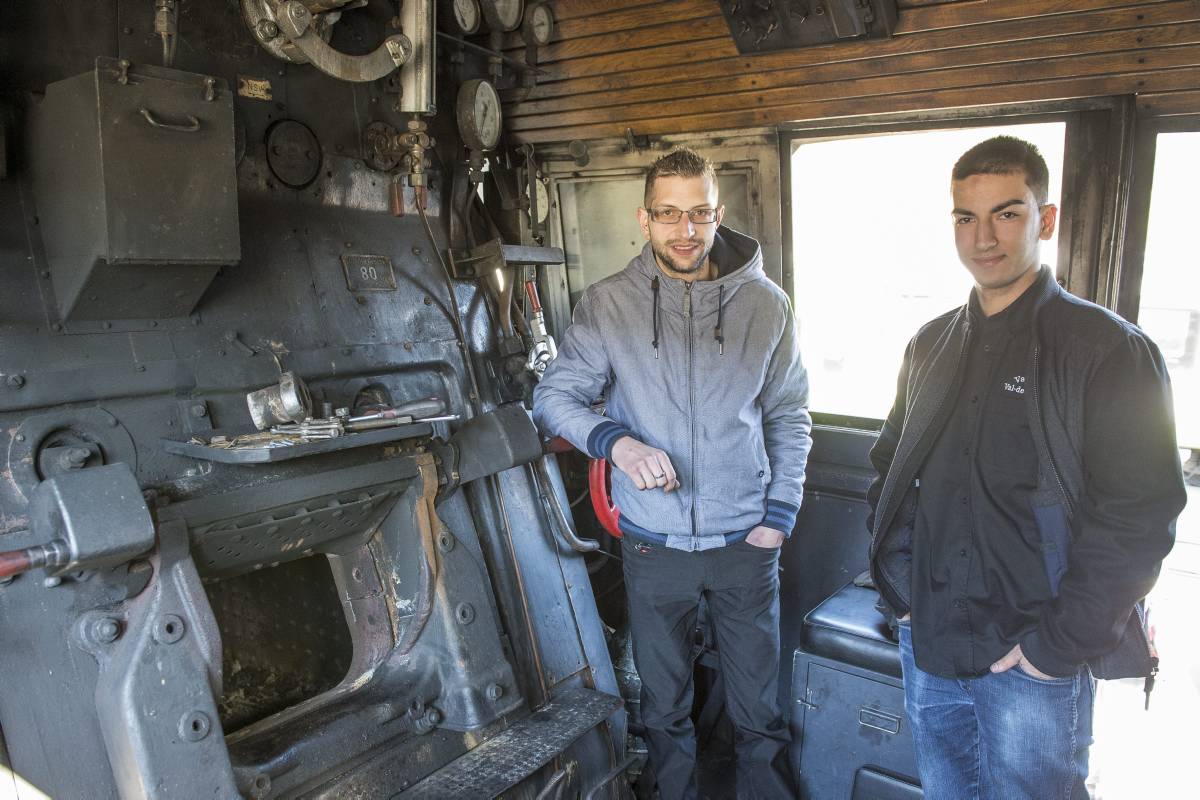 Dominique Marchand (veste grise) et Pablo Hoya (veste noire), président et vice-président du VVT, dans la cabine de conduite de la grosse locomotive à vapeur du club ferroviaire du Val-de-Travers.