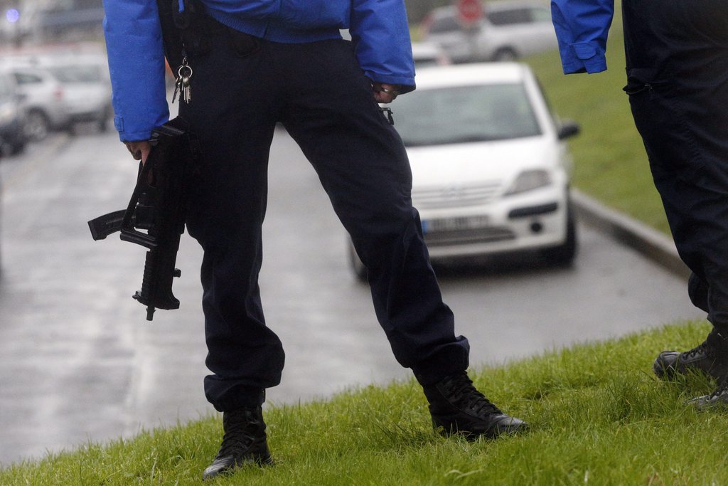 epa04551932 Police officers stand along a road near an industrial area where the suspects in the shooting attack at the satirical French magazine Charlie Hebdo headquarters are reportedly holding a hostage, in Dammartin-en-Goele, some 40 kilometres north-east of Paris, France, 09 January 2015. There has been an exchange of fire, according to media reports.  EPA/YOAN VALAT