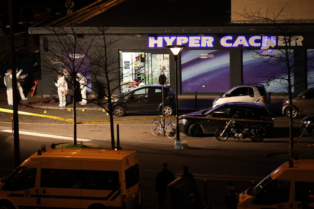 epa04553269 Forensic police officers stand by the body of alleged hostage-taker Amedy Coulibaly lying on the pavement in front of the Hyper Casher supermarket after the police raided the store, in Paris, France 09 January 2015. A hostage-taking was reported at a kosher grocery shop in the east of Paris on 09 January. The gunman was said to be the same shooter who had killed a policewoman in southern Paris on 08 January, identified as Amedy Coulibaly, 32. Hollande spoke of a 'dreadful anti-Semitic act.' Authorities had initially said there was no link between the 07 January Charlie Hebdo attack and the second shooting on 08 January, but French media reported that the Kouachi brothers and Coulibaly knew each other and had links with the same jihadist network. Coulibaly claimed during a phone conversation with the broadcaster BFMTV that the two attacks were coordinated.  EPA/MAYA VIDON-WHITE ATTENTION EDITORS: PICTURE CONTAINS GRAPHIC CONTENT. NO MAGAZINES EDITORIAL USE ONLY