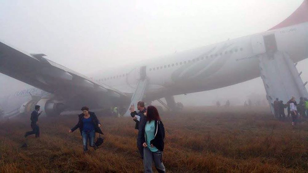epa04646681 A handout picture taken with a smartphone and made available from one of the passengers of a Turkish Airlines airbus, shows passengers evacuating the plane after it skidded off  the runway while landing at Tribhuvan International Airport in Kathmandu, Nepal, 04 March 2015. Four passengers were injured when a Turkish Airlines Airbus A330 made a rough landing at Kathmandu's airport on 04 March 2015, authorities said. One of the tyres of the plane burst during landing and it slipped off the runway on to the grass.  EPA/DIKESH MALHOTRA BEST AVAILABLE QUALITY HANDOUT EDITORIAL USE ONLY