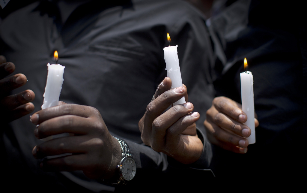 Kenyan students wearing black shirts to represent mourning hold candles as they march in memory of the victims of the Garissa college attack and to protest what they say is a lack of security, in downtown Nairobi, Kenya Tuesday, April 7, 2015. Hundreds of Kenyan students marched through downtown Nairobi on Tuesday to honor those who died in the attack on a college by Islamic militants and to press the government for better security in the wake of the slaughter. (AP Photo/Ben Curtis)