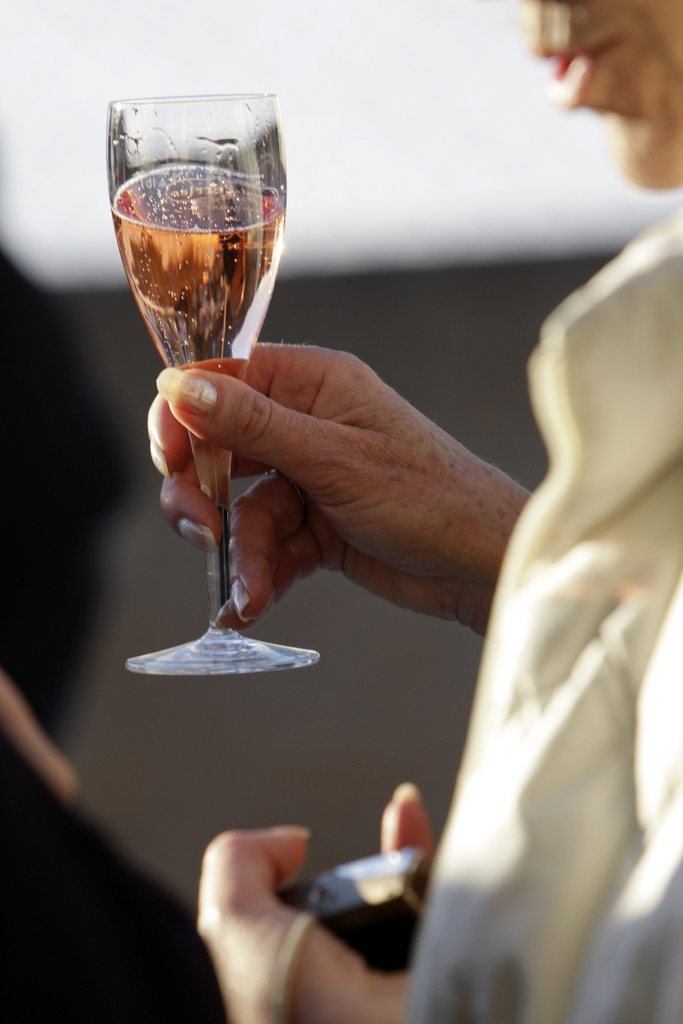 Une femme tiens un verre de champagne avant le debut du match de polo sur neige ce samedi 26 janvier 2008 au centre sportif de Verbier. La station de ski organise sa Polo Cup pour la premiere fois, deux equipes de deux personnes s'affrontent sur des cheveaux, pendant trois jours. (KEYSTONE/Jean-Christophe Bott)