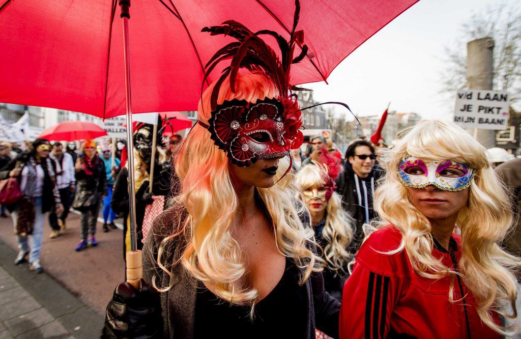 epa04697415 Sex workers and sympathizers demonstrate against the closure of window brothels by the municipality in the red light district in Amsterdm, The Netherlands, 09 April 2015. With 'Project 1012', the Amsterdam wants to close window prostitution to prevent crime, human trafficking and degradation.  EPA/ROBIN VAN LONKHUIJSEN