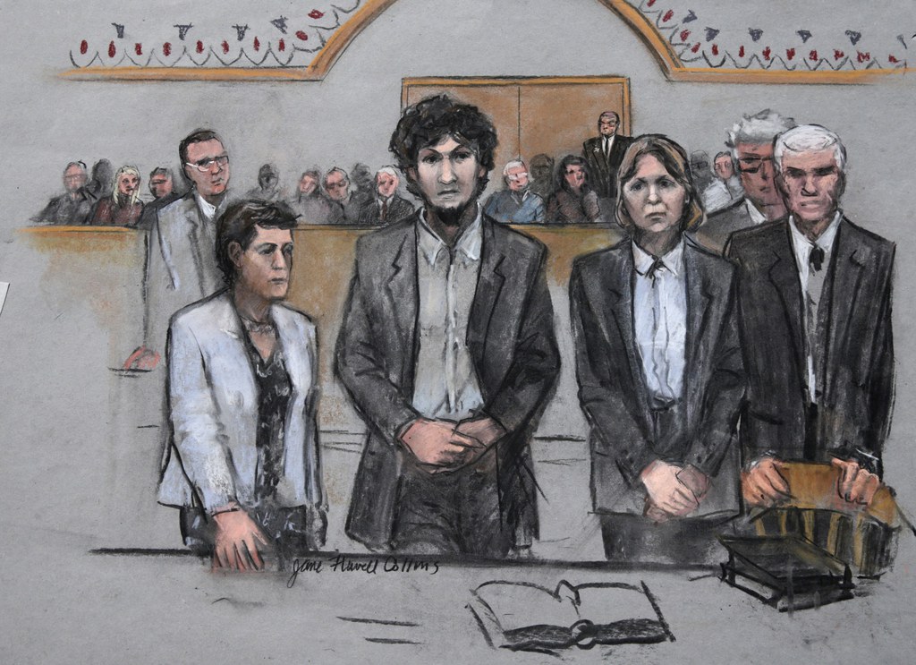 In this courtroom sketch, Boston Marathon bomber Dzhokhar Tsarnaev stands with his defense attorneys as a death by lethal injection sentence is read at the Moakley Federal court house in the penalty phase of his trial in Boston, Friday, May 15, 2015. The federal jury ruled that the 21-year-old Tsarnaev should be sentenced to death for his role in the deadly 2013 attack. (Jane Flavell Collins via AP)