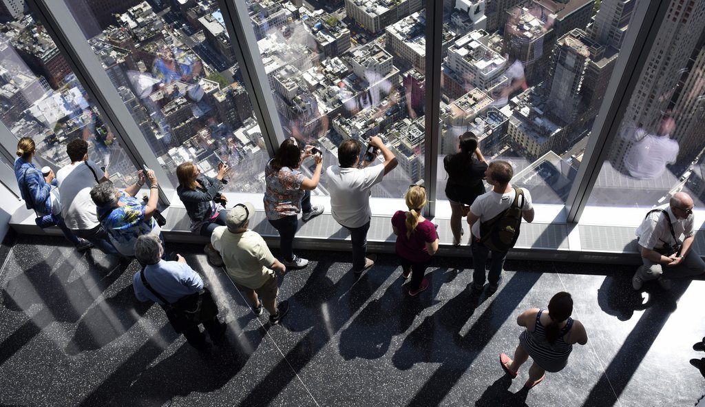 epa04774395 Visitors look out over city streets from the One World Observatory at One World Trade Center in New York, New York, USA, 29 May 2015. The observatory, which is on floors 100 to 102 of the building and allows panoramic views of the New York city area, officially opened to the public on 29 May.  EPA/JUSTIN LANE