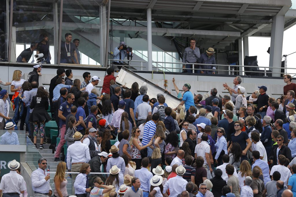 epa04780517 An object was falling onto spectators in  the stands as Jo-Wilfried Tsonga of France plays against Kei Nishikori of Japan during their quarterfinal match for the French Open tennis tournament at Roland Garros in Paris, France, 02 June 2015. The match was interrupted.  EPA/ROBERT GHEMENT