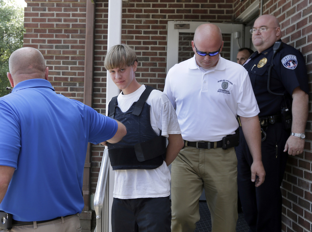 Charleston, S.C., shooting suspect Dylann Storm Roof, center, is escorted from the Sheby Police Department in Shelby, N.C., Thursday, June 18, 2015. Roof is a suspect in the shooting of several people Wednesday night at the historic The Emanuel African Methodist Episcopal Church in Charleston, S.C. (AP Photo/Chuck Burton)