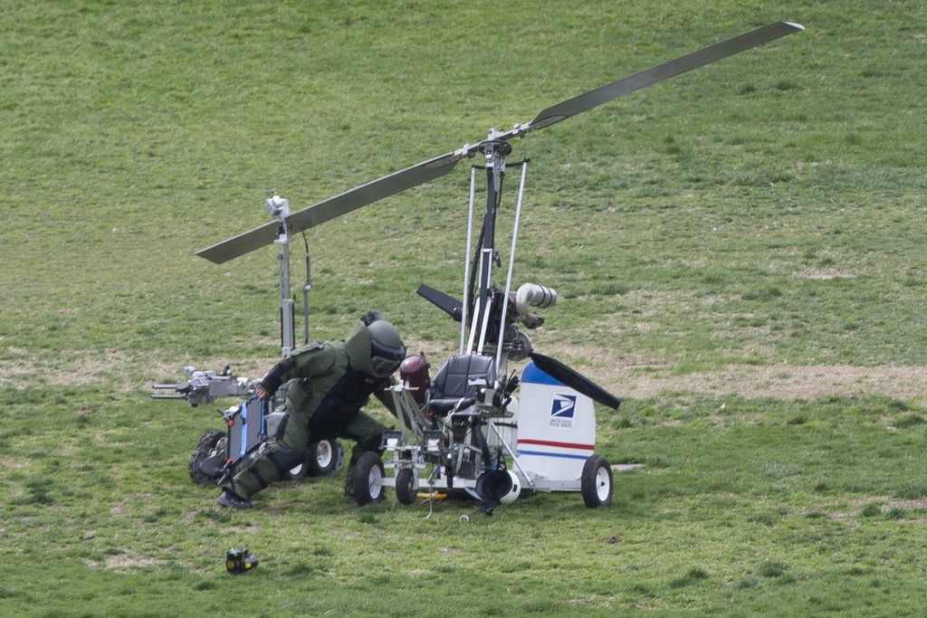 epa04706034 A member of a bomb squad works beside a bomb disposal robot (L) and a gyrocopter (R) after it landed on the West Front of the US Capitol, on Capitol Hill in Washington DC, USA, 15 April 2015. Reports state that a manned aircraft or gyrocopter landed on a lawn near the US Capitol. Police have arrested the pilot.  EPA/MICHAEL REYNOLDS