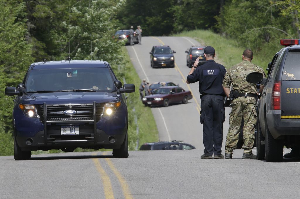 Law enforcement officials stand guard at a road block on Route 27 at the perimeter of the search for convicted murderer David Sweat, Saturday, June 27, 2015, in Duane, N.Y. Convicted murderer Richard Matt was shot and killed by a Border Patrol agent in a wooded area about 30 miles from the Clinton Correctional Facility on Friday, and David Sweat is on the run, authorities said. (AP Photo/Mary Altaffer)