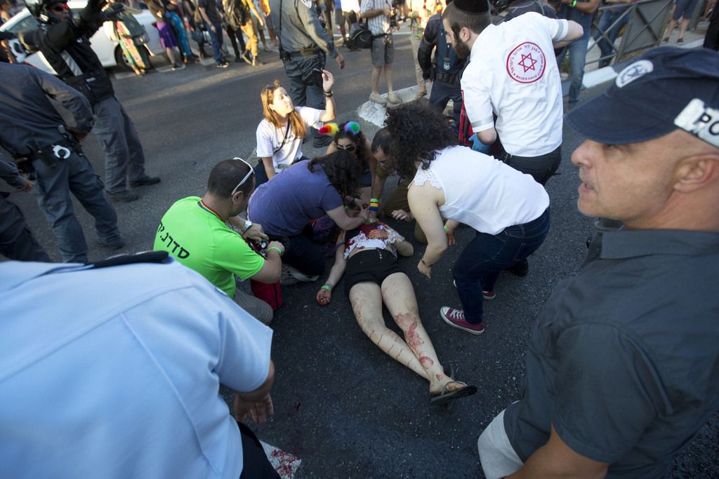 Paramedics help a wounded woman after an ultra-Orthodox Jew attacked people with a knife during a Gay Pride parade Thursday, July 30, 2015 in central Jerusalem. Israeli police said several people were stabbed. (AP Photo/Sebastian Scheiner)