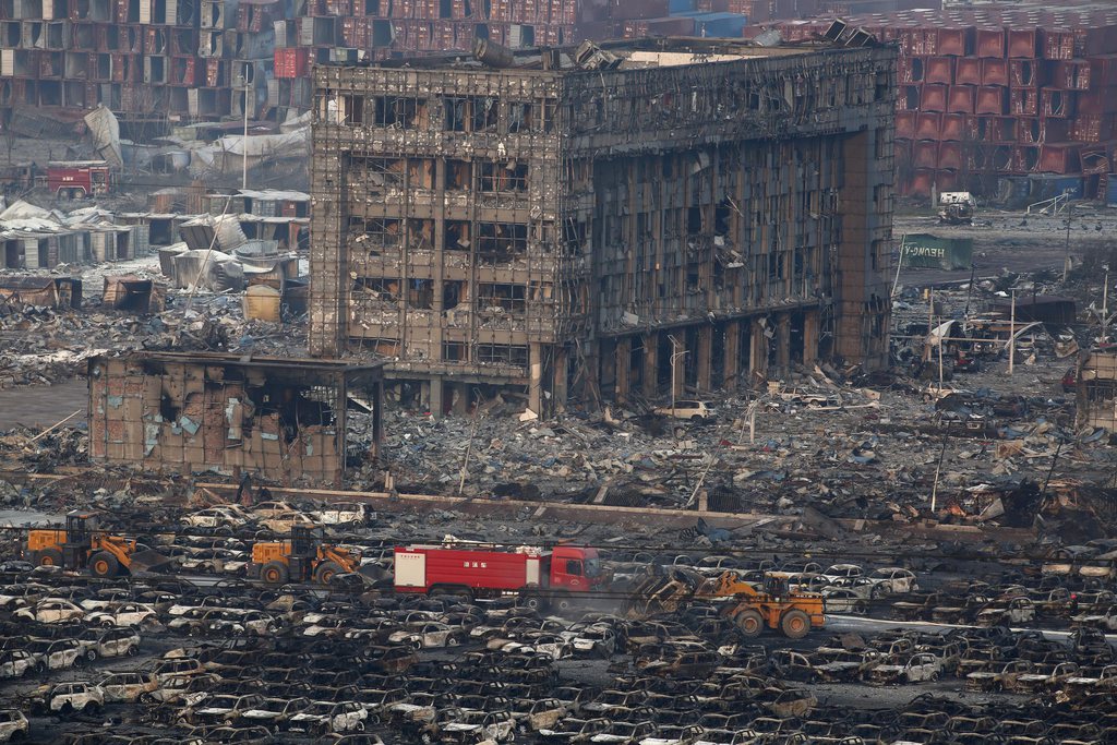 epa04881943 Rescuers work among hundreds of burned cars after a huge explosion rocked the port city of Tianjin, China, 13 August 2015. According to reports, at least 44 people were killed after a large explosion rocked the north-eastern Chinese city of Tianjin Fifty-two people were critically injured out of a total of 521 people in hospital after the blast and fireball in the port city, local authorities said.  EPA/WU HONG