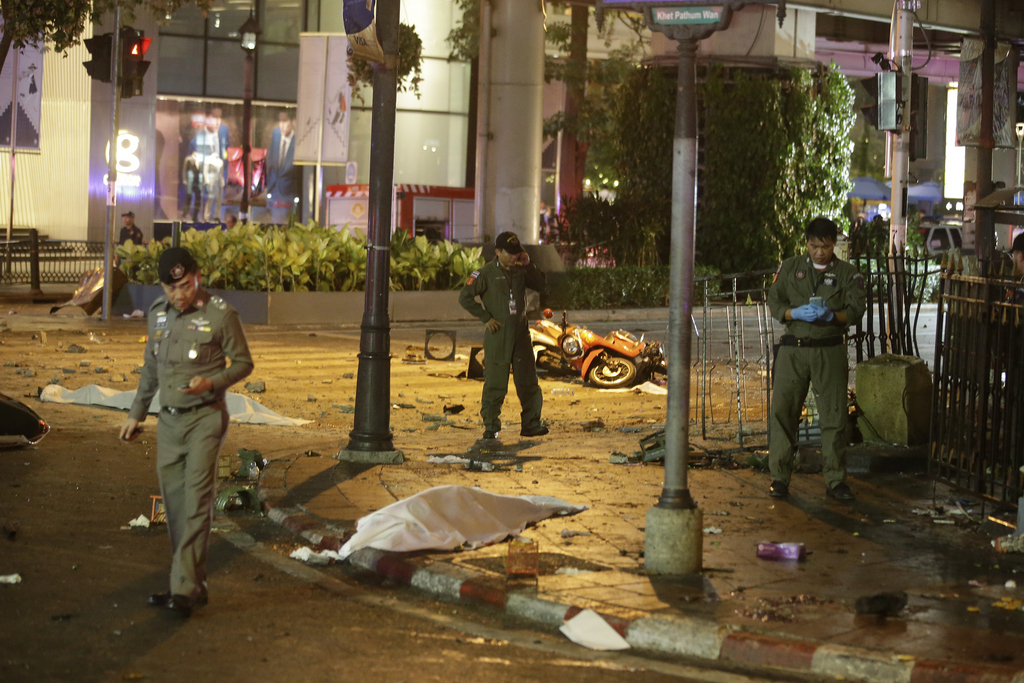 Security personnel gather at the intersection near an explosion in Bangkok, Monday, Aug. 17, 2015. A large explosion rocked a central Bangkok intersection during the evening rush hour, killing a number of people and injuring others, police said. (AP Photo/Sackchai Lalit)