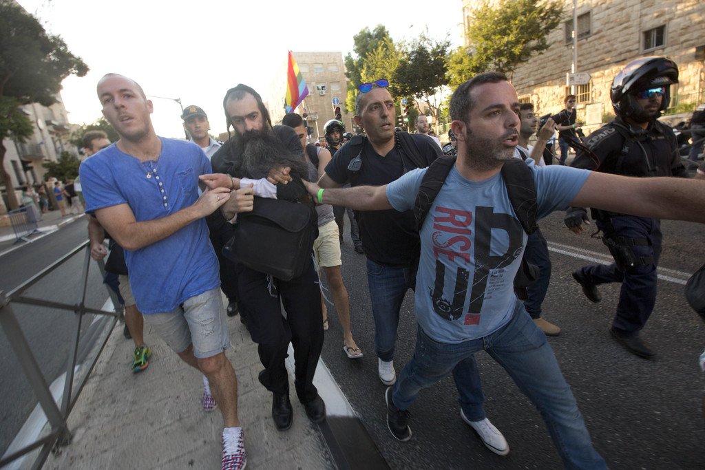 In this Thursday, July 30, 2015 photo, policemen arrest Yishai Schlissel, an ultra-Orthodox Jewish man, after he lunged into a group of revelers at the annual gay pride parade and stabbed several of them in Jerusalem as they marched in the holy city, Israeli police and witnesses said. (AP Photo/Sebastian Scheiner)