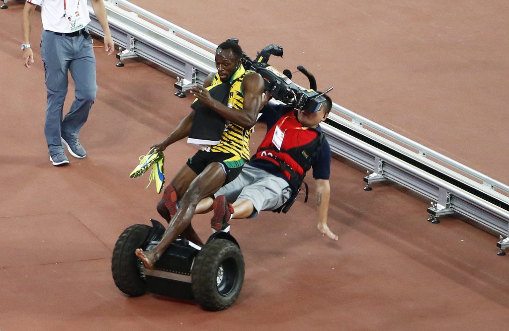epa04900474 A Tv cameraman drives into Usain Bolt of Jamaica after the men's 200m final during the Beijing 2015 IAAF World Championships at the National Stadium, also known as Bird's Nest, in Beijing, China, 27 August 2015. Bolt won the race.  EPA/ROLEX DELA PENA