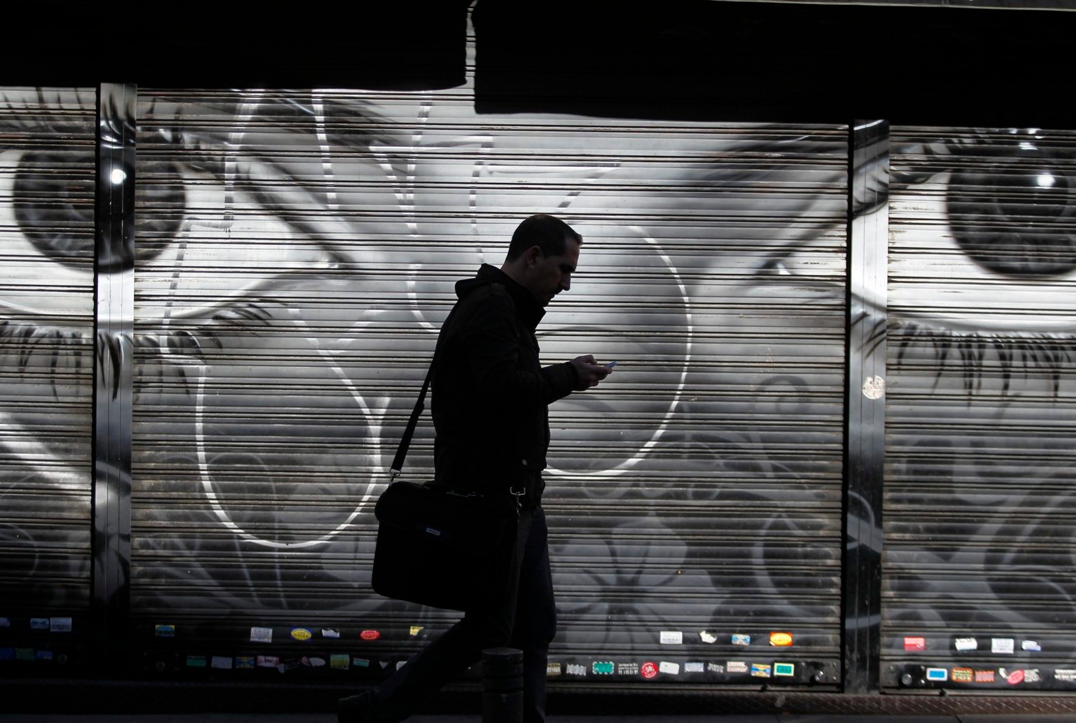 FILE - In this Thursday, Oct. 31, 2013, file photo, a man looks at his cellphone as he walks on the street in downtown Madrid. The National Security Agency tracks the locations of nearly 5 billion cellphones every day overseas, including those belonging to Americans abroad, The Washington Post reported Wednesday, Dec. 4, 2013. (AP Photo/Francisco Seco, File) NSA Surveillance-Tracking Cellphones