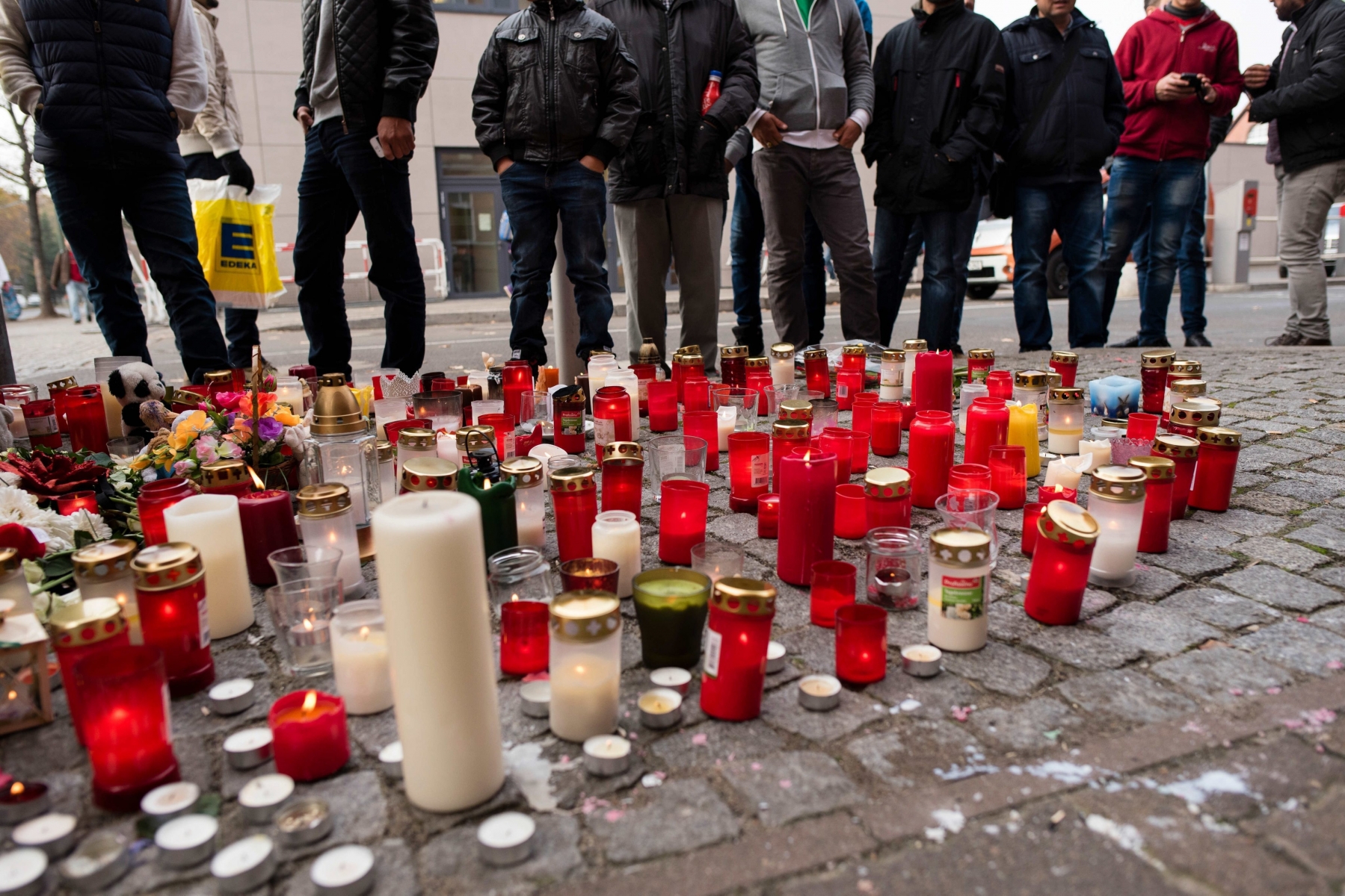 epa05003281 Candles burn in memory of the migrant child Mohamed, on the Lageso in Berlin, Germany, 29 October 2015. A 32-year-old man was arrested at a house in Niedergoersdorf and it is alleged that he confessed to kidnapping and murdering a refugee boy named Mohamed four weeks ago in Berlin.  EPA/GREGOR FISCHER GERMANY CRIME