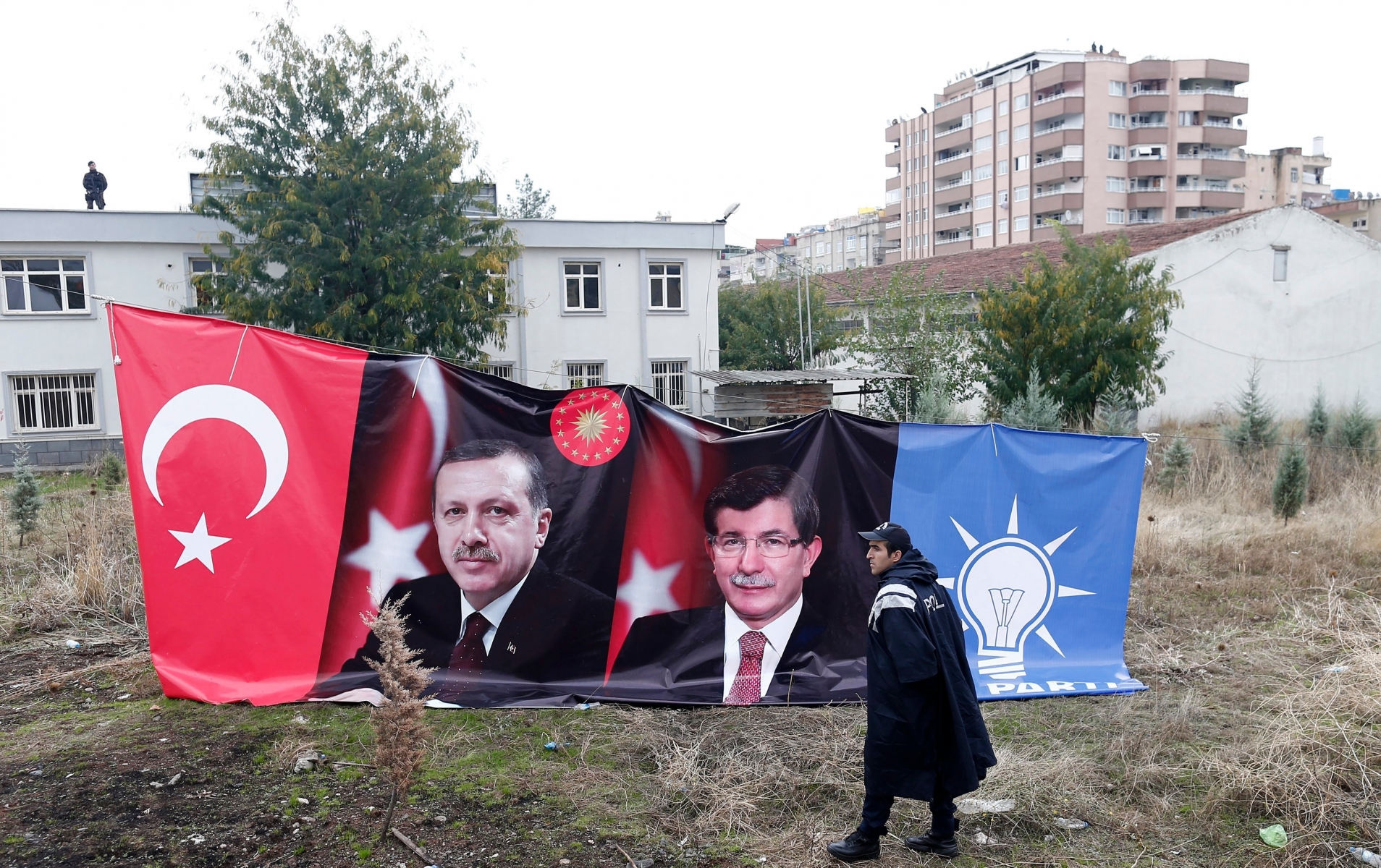 epa05001997 A Turkish police guard front of pictures of the Turkish Prime Minister Ahmet Davutoglu and Turkish President Recep Tayyip Erdogan during an general election rally  in Diyarbakir, Turkey, 29 October 2015. Turkey's general elections will be held on 01 November 2015.  EPA/SEDAT SUNA TURKEY GENERAL ELECTION