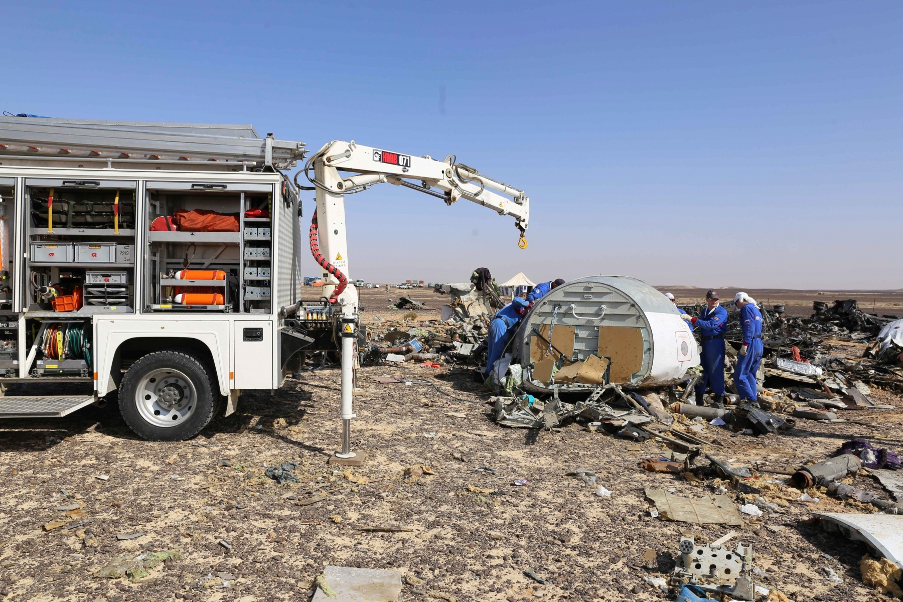 In this Russian Emergency Situations Ministry photo, made available on Monday, Nov. 2, 2015, Russian Emergency Ministry experts work at the crash site of a Russian passenger plane bound for St. Petersburg in Russia that crashed in Hassana, Egypt's Sinai Peninsula, on Monday, Nov. 2, 2015. A Russian cargo plane on Monday brought the first bodies of Russian victims home to St. Petersburg, from Egypt.(Russian Ministry for Emergency Situations photo via AP) Egypt Russian Plane Crash