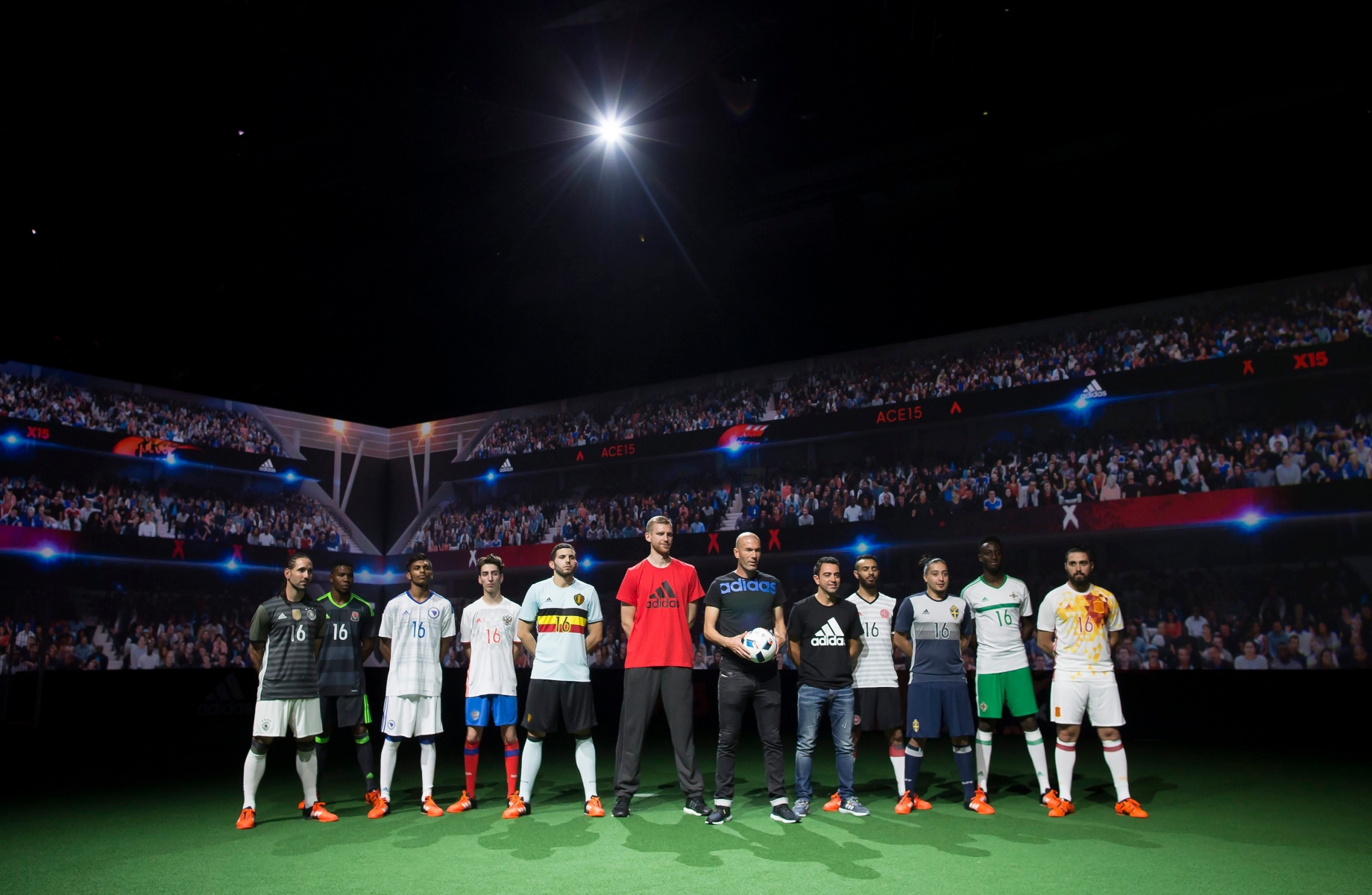 epa05022398 Former French soccer player Zinedine Zidane (C) holds the official UEFA Euro 2016 soccer ball, dubbed 'Beau Jeu' (Beautiful Game), flanked by German soccer player Per Mertesacker (6-L), Spanish soccer player Xavi Hernández (5-R) and participants wearing away-jerseys of competing nations, during a media event in Saint-Denis, outside Paris, France, 12 November 2015.  EPA/IAN LANGSDON FRANCE SOCCER UEFA EURO 2016