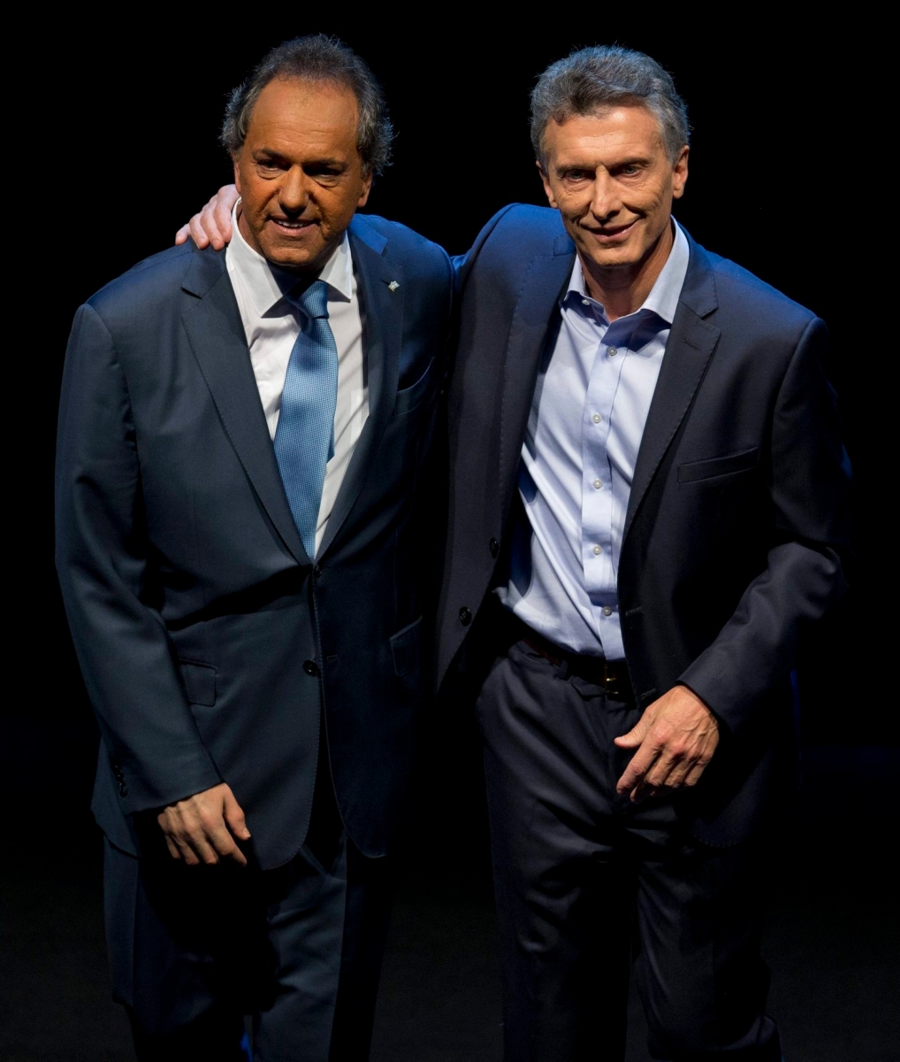 In this Nov. 15, 2015 photo, opposition presidential candidate Mauricio Macri, right, and Daniel Scioli, the ruling party presidential candidate embrace each other on stage at the end of the presidential debate in Buenos Aires, Argentina. Macri will face Scioli in a Nov. 22 runoff. Macri promises to maintain a safety net for the poor but says he will overhaul the economy to address inflation estimated around 30 percent and a byzantine monetary system that has spawned a booming black market. (AP Photo/Natacha Pisarenko) Argentina Elections