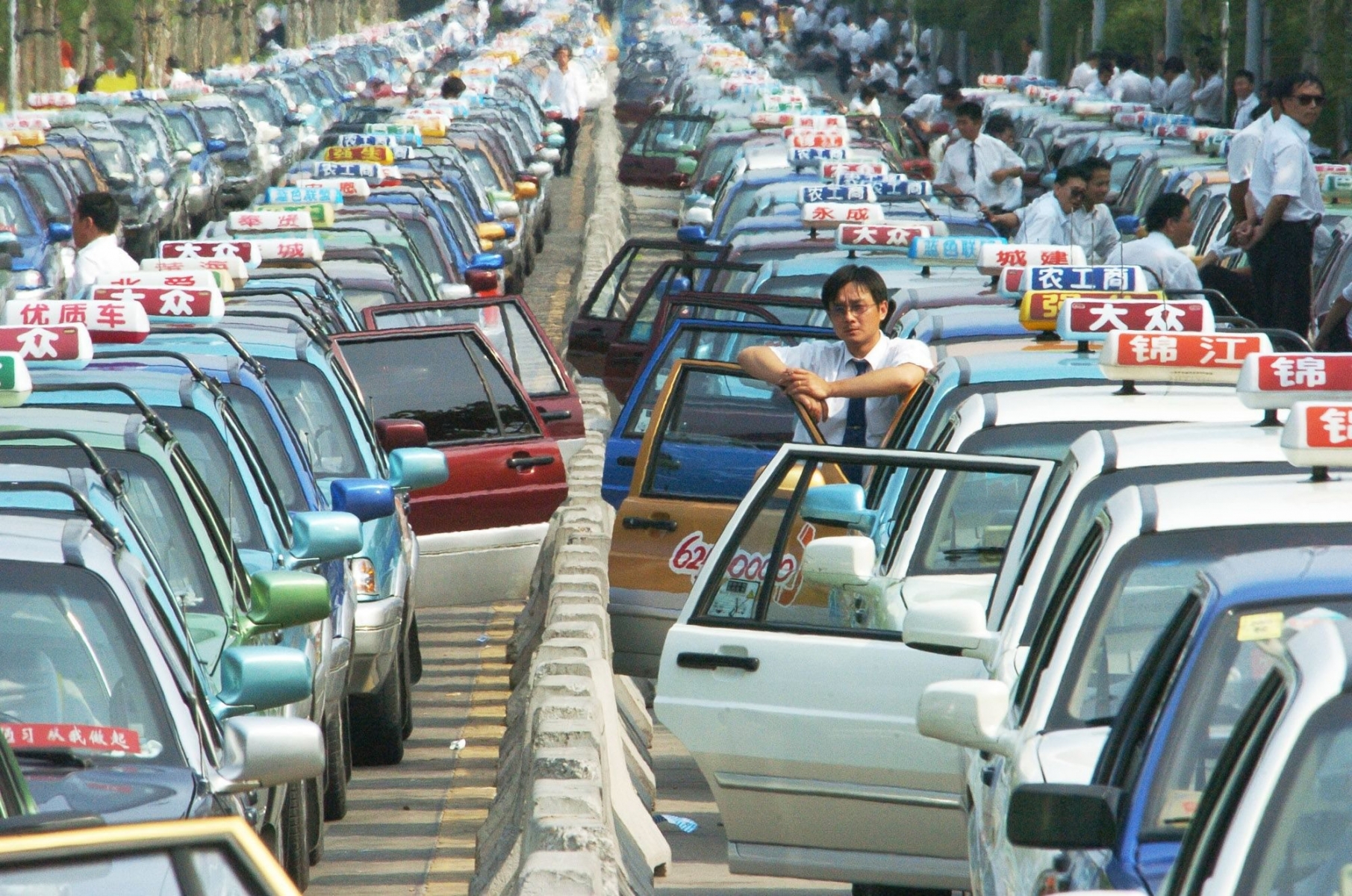 Taxis wait in lines for customers outside the Pudong International Airport in Shanghai, east China, Wednesday, June 15, 2005. About 2,500 cabs wait there everyday because the airport is 50 kilometers (30 miles) away from downtown Shanghai and the drivers will suffer a loss if they don't take a customer back to the city. Drivers often have to wait for five hours before reaching the front of the line to pick up a customer at the airport. (AP Photo) **ONLINE OUT, CHINA OUT ** CHINA TAX QUEUE