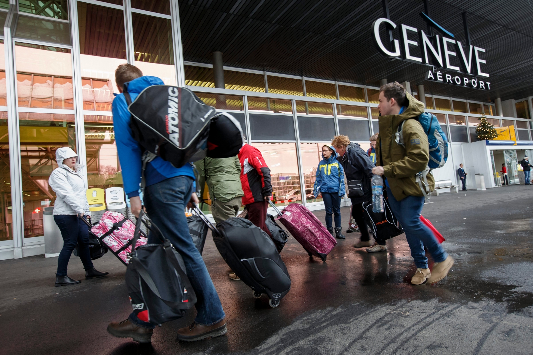 Flight passengers, with their luggages, arrive in the arrival hall of the Geneva Airport, in Geneva, Switzerland, Saturday, December 27, 2014. Thousands of skiers and travellers are expected during this week end at the airport after have celebrated Christmas day in ski resorts of Switzerland or in ski resorts of France. (KEYSTONE/Salvatore Di Nolfi) SWITZERLAND GENEVA AIRPORT