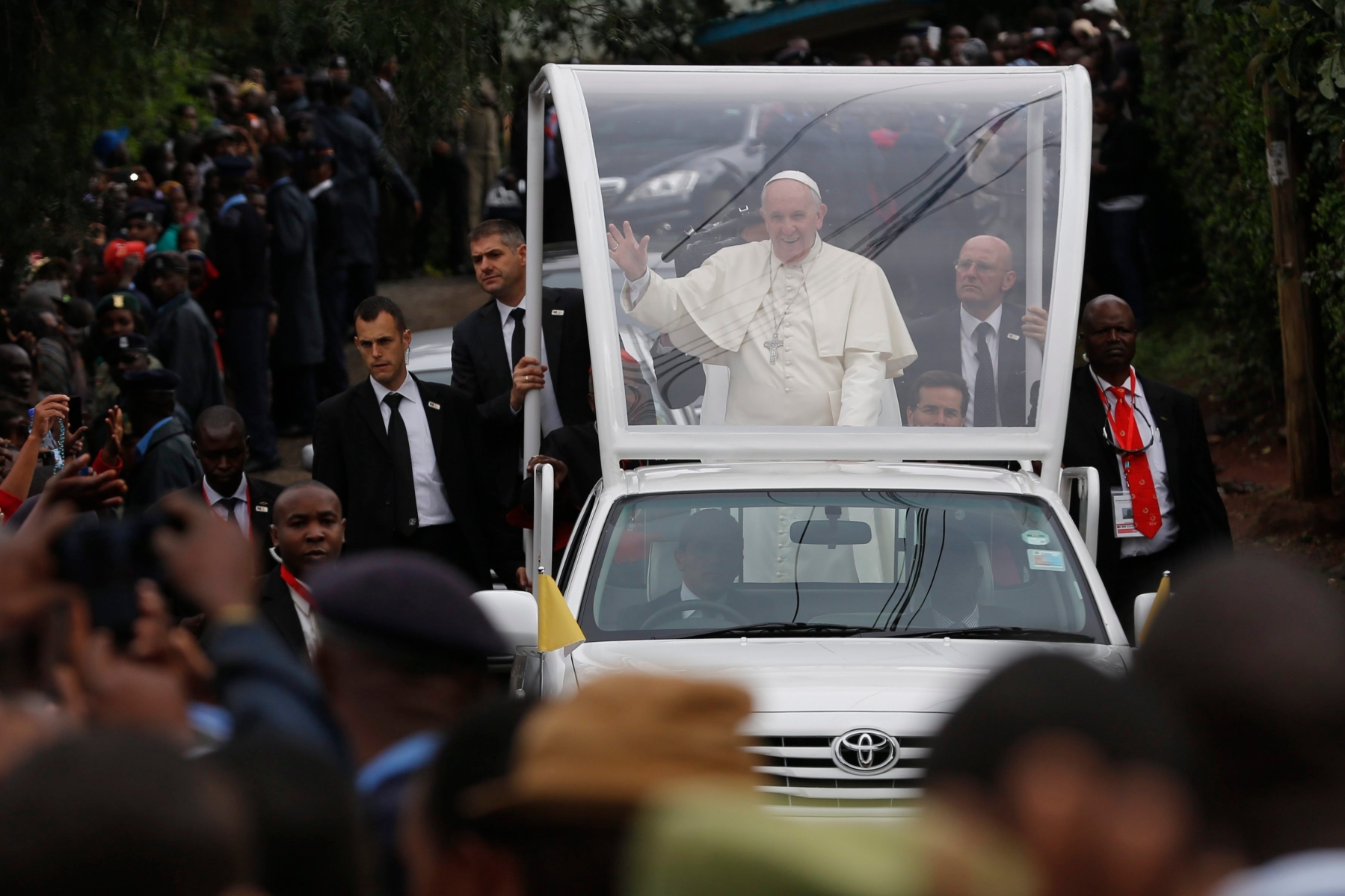 epa05043843 Pope Francis (C) waves at faithfuls as he arrives with the Popemobile to attend a mass at St Joseph Catholic church in Kangemi slum in Nairobi, Kenya, 27 November 2015. Hundreds of worshippers attended a mass. Pope Francis is on his three-nation African tour.  EPA/DAI KUROKAWA KENYA POPE FRANCIS VISIT