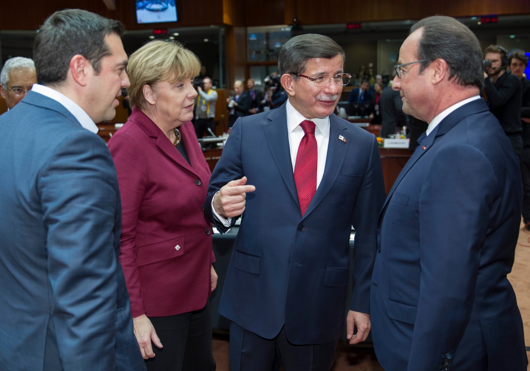 epa05047819 (L-R) Greek Prime Minister Alexis Tsipras, German Chancellor Angela Merkel chats with Turkish Prime Minister Ahmet Davutoglu and French President Francois Hollande, at the start of an extraordinary EU Summit with Turkey in Brussels, Belgium, 29 November 2015. The European Union hopes to secure Ankara's concrete help in stemming a surge in migration, at a joint summit in Brussels, with the bloc offering financial aid and closer ties in return. Europe is facing its largest people movements since World War II, with almost 900,000 migrants and asylum seekers arriving this year. Many, including large numbers from war-torn Syria, transit through Turkey and board boats headed for Greece.  EPA/OLIVIER HOSLET BELGIUM EU TURKEY SUMMIT