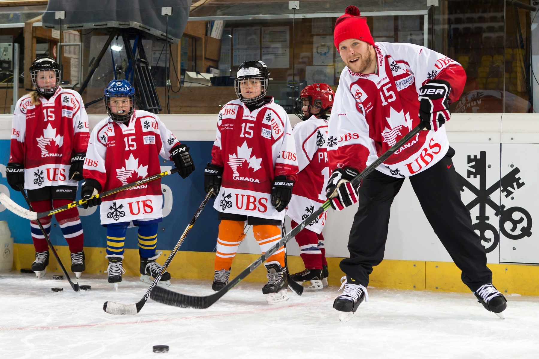 Team Canada's Daniel Vukovic, right, instruct children's during a children's training session during the 89th Spengler Cup ice hockey tournament in Davos, Switzerland, Monday, December 28, 2015. (KEYSTONE/Pascal Muller) EISHOCKEY SPENGLER CUP 2015 KIDS DAY