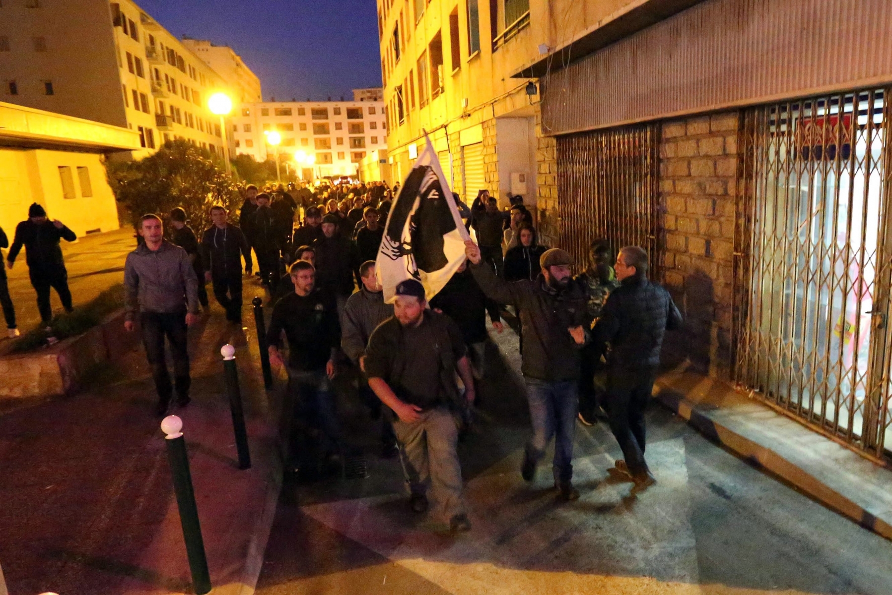 FILE - This Saturday, Dec. 26, 2015 file photo shows demonstrators, most of them angry against Muslim residents, marching behind the Corsican flag in Ajaccio, on the French Mediterranean island of Corsica. Frances interior minister is seeking to halt violence in Corsica after protesters vandalized a Muslim prayer room in anger over an ambush of firefighters. Bernard Cazeneuve, visiting the Corsican city of Ajaccio on Wednesday, told reporters there is no place in Corsica for violence or racism. (AP Photo/Jean-Pierre Belzit, File) France Corsica
