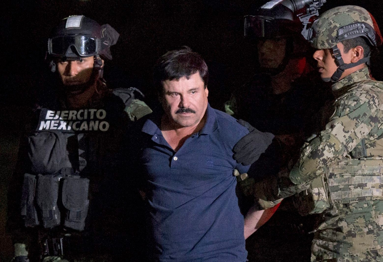 ALTERNATIVE CROP OF RLB111.- Mexican drug lord Joaquin "El Chapo" Guzman is escorted by army soldiers  to a waiting helicopter, at a federal hangar in Mexico City, Friday, Jan. 8, 2016. The world's most wanted drug lord was recaptured by Mexican marines Friday, six months after he fled through a tunnel from a maximum secuirty prison in a made-for-Hollywood escape that deeply embarrassed the government and strained ties with the United States. (AP Photo/Rebecca Blackwell) Mexico Drug Lord
