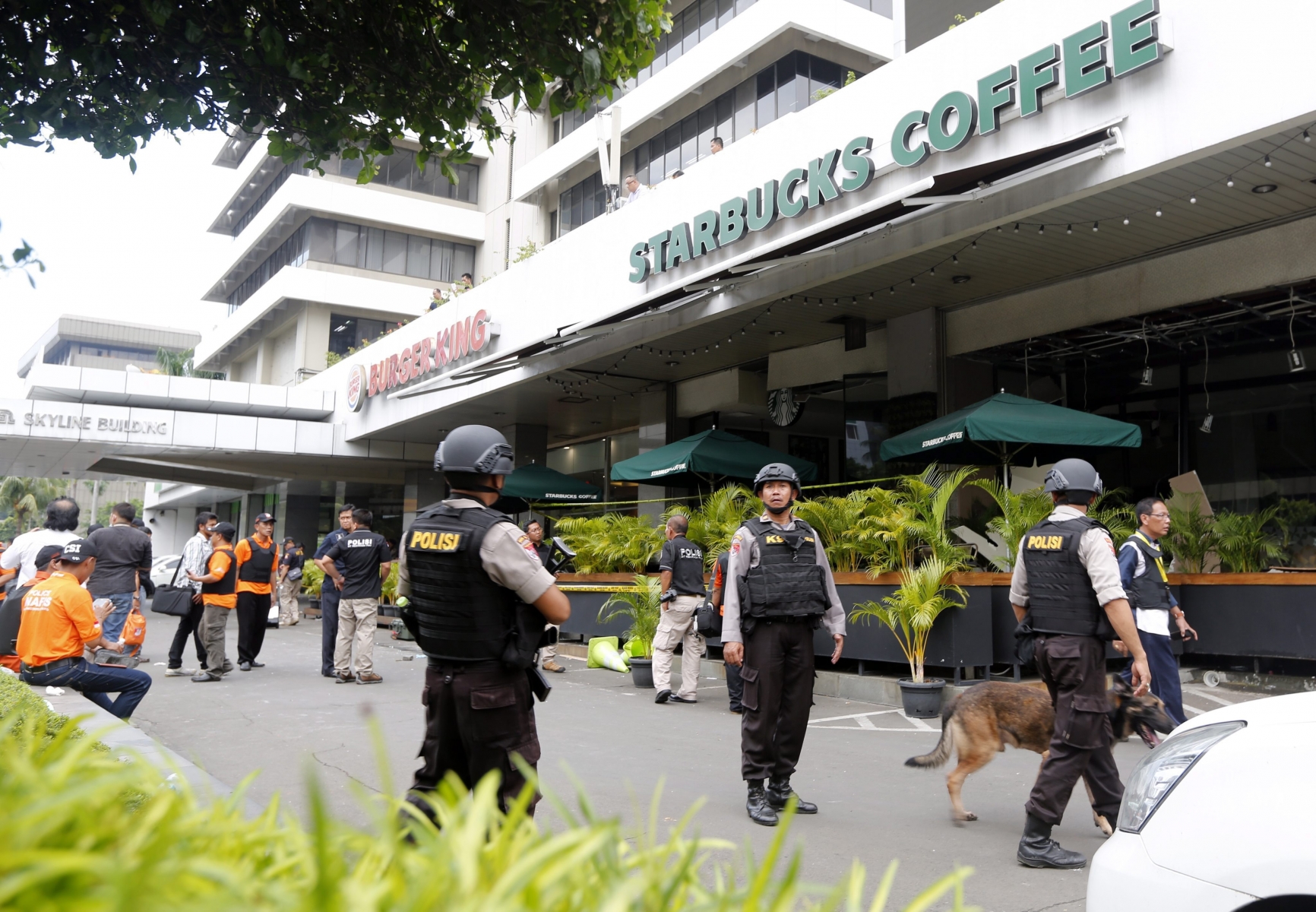 epa05101170 Indonesian police officers stand guard in front of a Starbucks cafe after a bomb blast in front of a shopping mall in Jakarta, Indonesia, 14 January 2016. Seven people, including four suspected attackers, died in bomb blasts and gunfire in the centre of the Indonesian capital Jakarta on 14 January, police said, in what the country's president described as an act of terrorism.  EPA/BAGUS INDAHONO INDONESIA JAKARTA BOMB BLAST