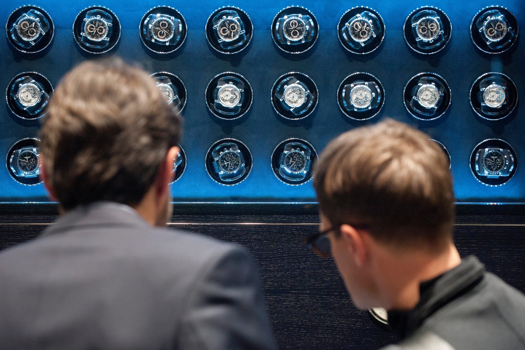 Visitors look a wall made of watches or timepieces Montblanc, during the first day of the 21th edition of the Salon International de la Haute Horlogerie, SIHH, in Geneva, Switzerland, on Monday, January 17, 2011. The SIHH is a private trade fair, reserved exclusively for professionals in Fine Watchmaking who are invited by the exhibiting brands. (KEYSTONE/Sandro Campardo) SWITZERLAND SIHH SALON INTERNATIONAL HAUTE HORLOGERIE