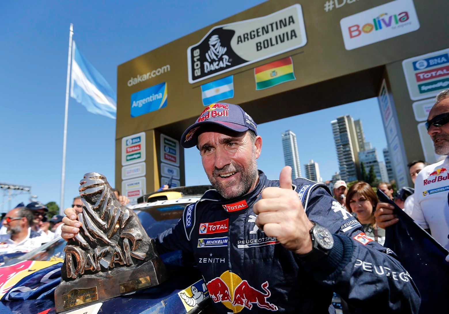 Peugeot driver Stephane Peterhansel, of France, flashes a thumb up after receiving a 2016 Dakar Rally winner's trophy, in Rosario, Argentina Saturday, Jan. 16, 2016. Peterhansel won the Dakar Rally for the 12th time - sixth in a car - after finishing in the 13th and final stage on Saturday. (AP Photo/Jorge Saenz) Argentina Rally Dakar