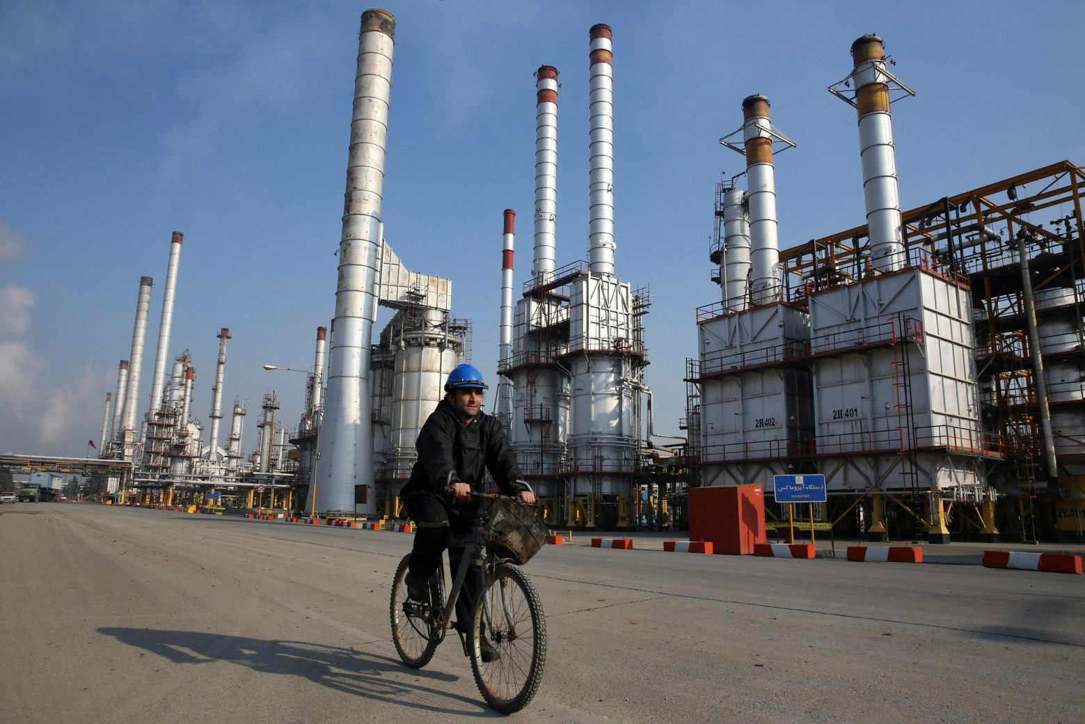 FILE - In this Dec. 22, 2014 file photo, an Iranian oil worker rides his bicycle at the Tehran's oil refinery south of the capital Tehran, Iran. With a historic nuclear deal between Iran, the U.S. and five other world powers set into place this weekend, a European oil embargo on the world's seventh-largest oil producer will end. The most immediate fallout may be a steep drop in crude oil prices starting with the Asian market on Monday, Jan. 18, 2016. (AP Photo/Vahid Salemi, File) Iran Nuclear Deal Oil