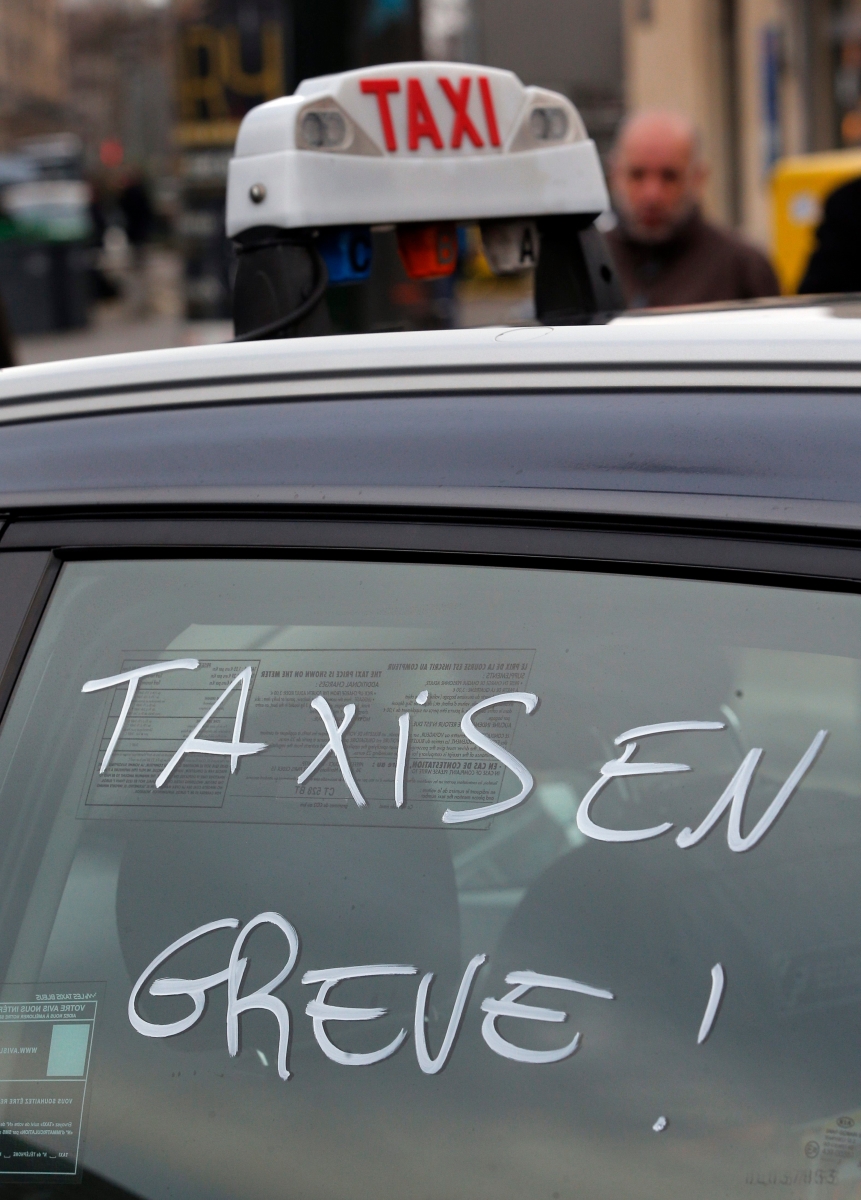 "Taxi on strike" is written on a cab during a blockade by taxi drivers in Paris, Tuesday, Jan. 26, 2016. Paris taxi drivers protesting what they consider unfair competition from rival services such as Uber are joining teachers and other public servants in nationwide strikes and demonstrations. (AP Photo/Christophe Ena) France Strikes