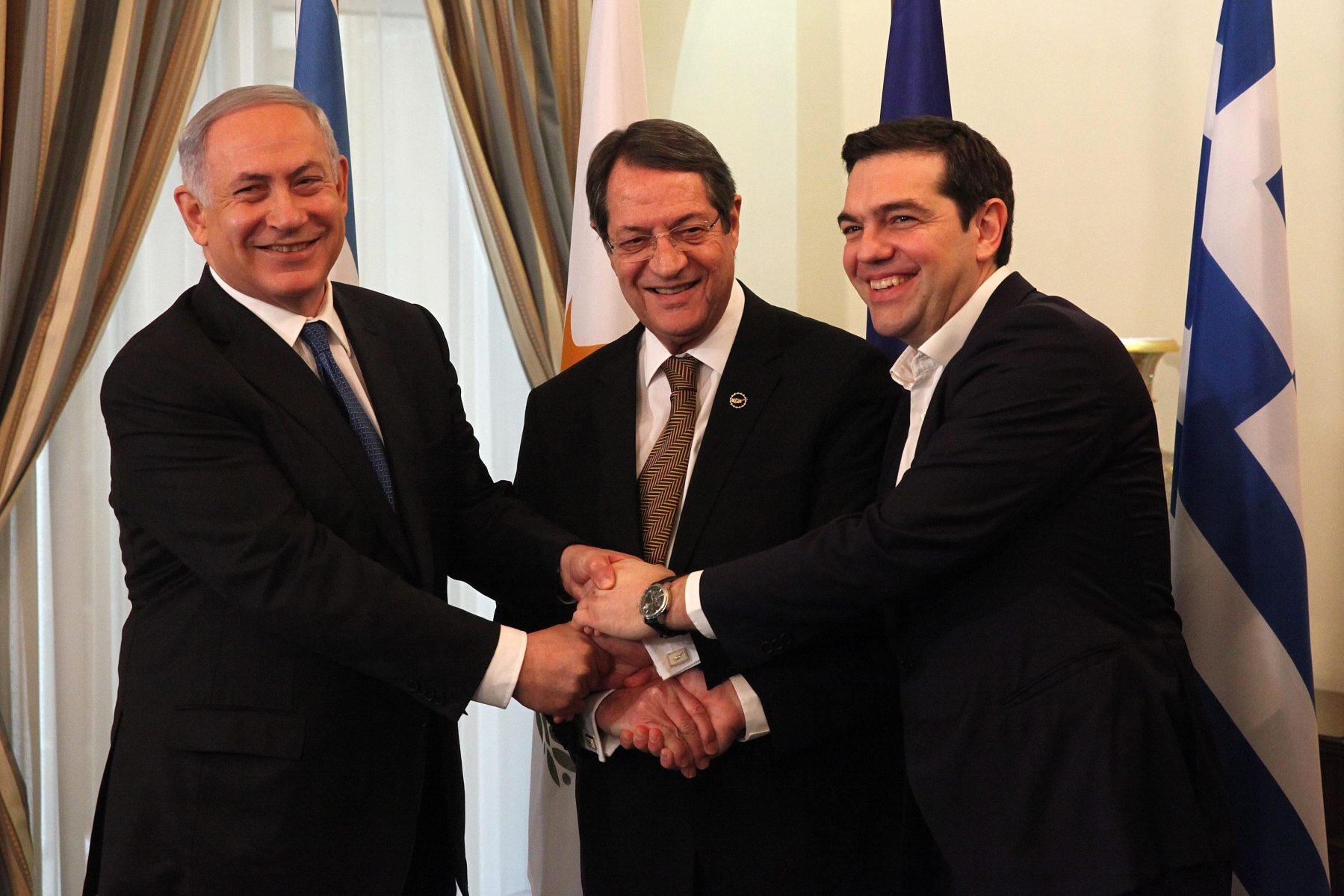 epa05131344 President of Cyprus Nikos Anastasiades (C), Israeli Prime Minister Benjamin Netanyahu (L) and Greek Prime Minister Alexis Tsipras (R) shake hands during their meeting at the Presidential Palace in Nicosia, Cyprus, 28 January 2016. Cyprus-Greece-Israel tripartite economic relations meeting on shipping, tourism and energy in Nicosia, aimed at establishing greater cooperation in the eastern Mediterranean.  EPA/YIANNIS KOURTOGLOU / POOL