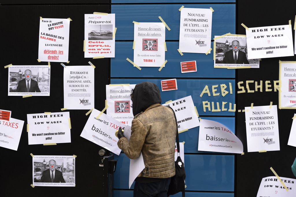 Des étudiants collent des affiches sur la façade du bureau du rectorat de l'EPFL.