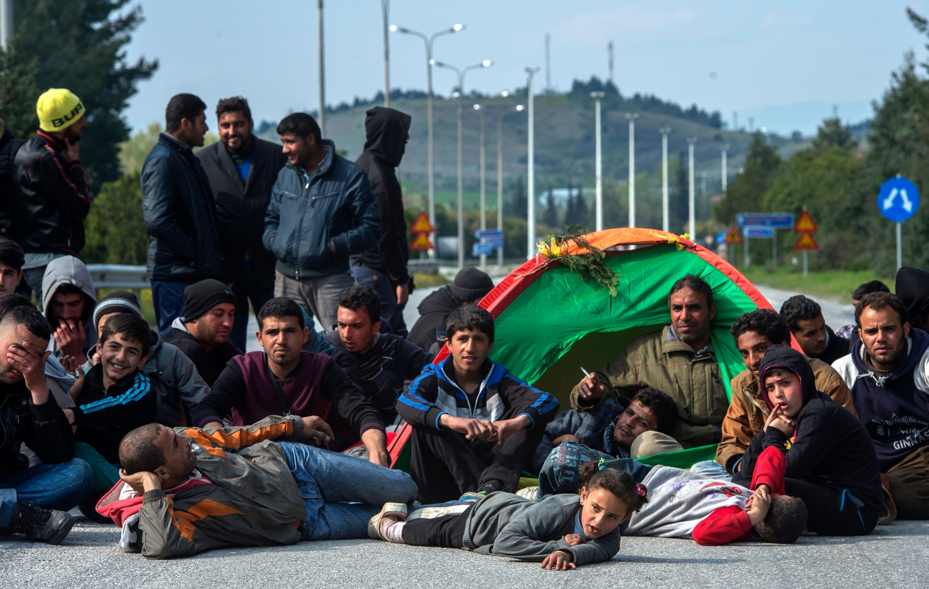 epa05233604 Refugees and migrants blocking the highway to the border crossing of Evzoni during a protest demanding the opening of the borders near the Greek - Macedonian border in northern Greece on 28 March 2016. Migration restrictions along the so-called Balkan route, the main path for migrants and refugees from the Middle East into the European Union, has left thousands of migrants trapped in Greece.  EPA/GEORGI LICOVSKI GREECE REFUGEE MIGRATION CRISIS