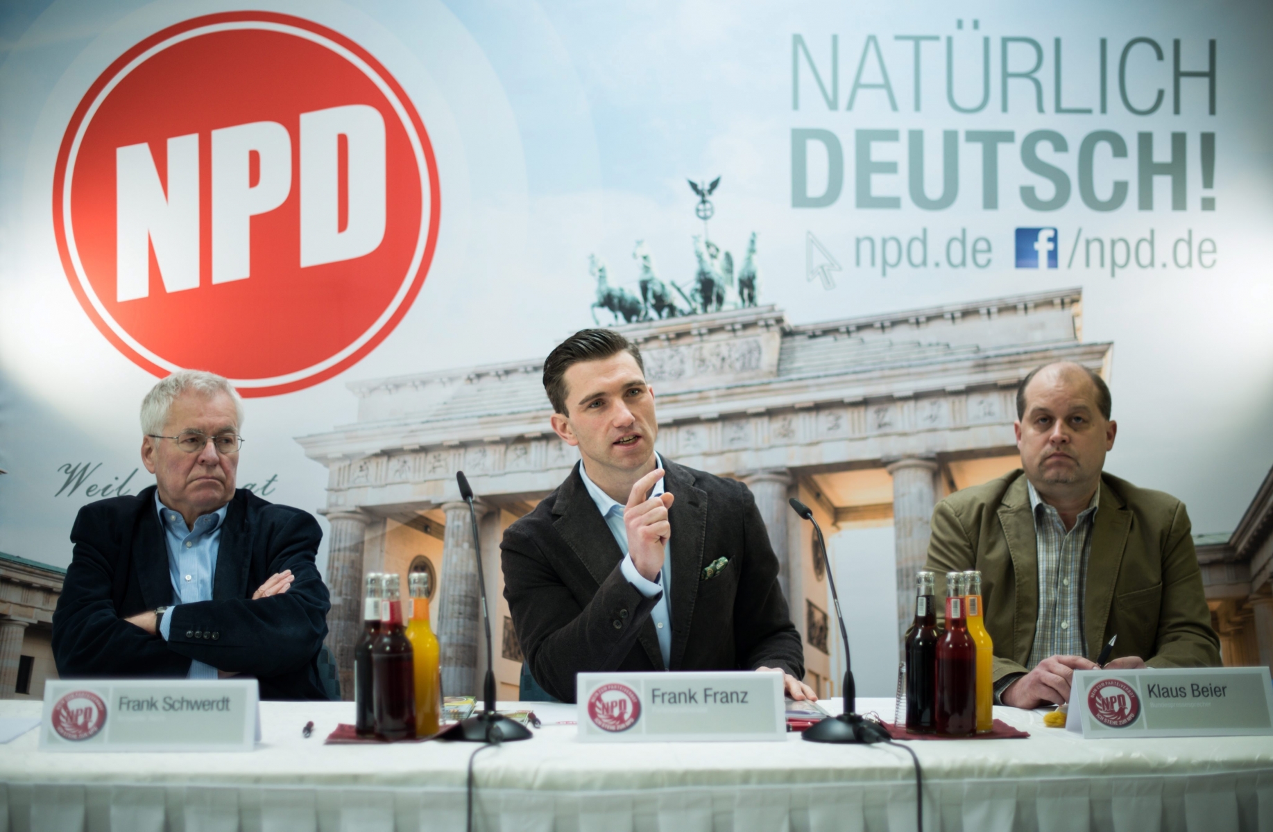 epa05199273 (L-R) Frank Schwerdt, deputy federal chairman of the German right-wing extremist National Democratic Party (NPD), Frank Franz, NPD federal chairman, and Klaus Beier, federal whip, speak at a press conference on the proceedings in the NPD ban and the coming parliamentary elections in thye party's headquarters in Berlin, Germany, 07 March 2016. Slogan in background reads: 'Naturally German!'. An effort by  the NPD on 02 March to have a ban request against it thrown out on the basis that state informants are active in its ranks has failed at the Constitutional Court, which is hearing a landmark request from Germany's 16 federal states to ban the ultranationalist party. A previous attempt to ban the party failed in 2003 because the presence of undercover informants from the domestic intelligence agency in its upper echelons was seen as weakening the evidence.  EPA/BERND VON JUTRCZENKA . GERMANY POLITICS PARTIES NATIONALISTS