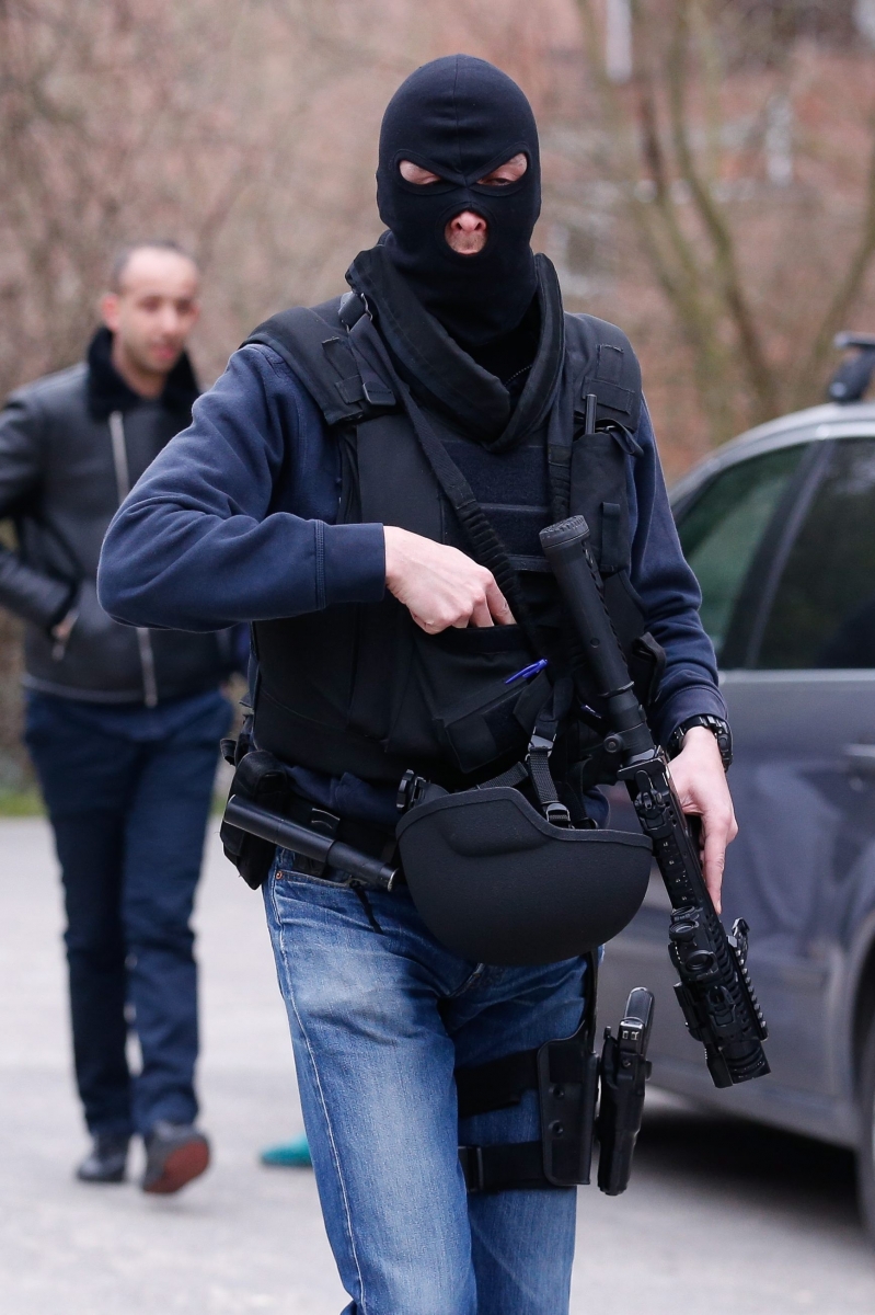 epa05213036 Police officers take position during a police operation in Forest, Brussels, Belgium, 15 March 2016. A major police operation was underway after shots were fired during an anti-terror raid in Brussels. Three officers were lightly injured, police said. The raid was linked to the 13 November Paris Attacks. It was confirmed by the French Interior Minister that French Police were taking part in the operation alongside their Belgian colleagues.  EPA/LAURENT DUBRULE BELGIUM POLICE RAID SHOOTOUT