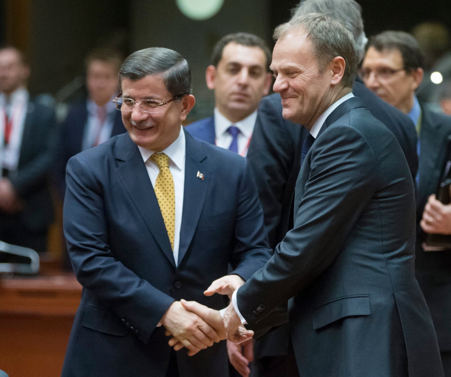 epa05218535 Turkish Prime Minister Ahmet Davutoglu (L) and European Council President Donald Tusk (R) shake hands during a meeting on the second day of the European Union leaders summit in Brussels, Belgium, 18 March 2016. EU leaders met to discuss a deal with Turkey that is aimed to tackle the migration crisis and curb migration into the bloc.  EPA/OLIVIER HOSLET BELGIUM EU SUMMIT