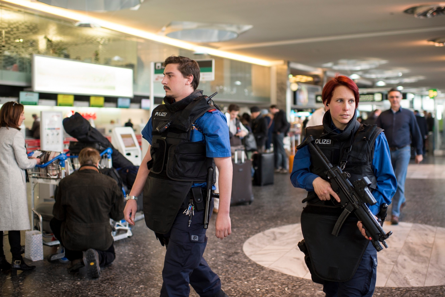 Police officers indicate their presence at the Airport of Zurich, in Zurich-Kloten, Switzerland, Tuesday, 22 March 2016. All flights to brussels are canceled and security measures have been raised following the terror attacks at Brussels airport and on the metro system which claimed multiple lives and injured many others. (KEYSTONE/Ennio Leanza) SCHWEIZ FLUGHAFEN ZUERICH BRUESSEL ANSCHLAEGE
