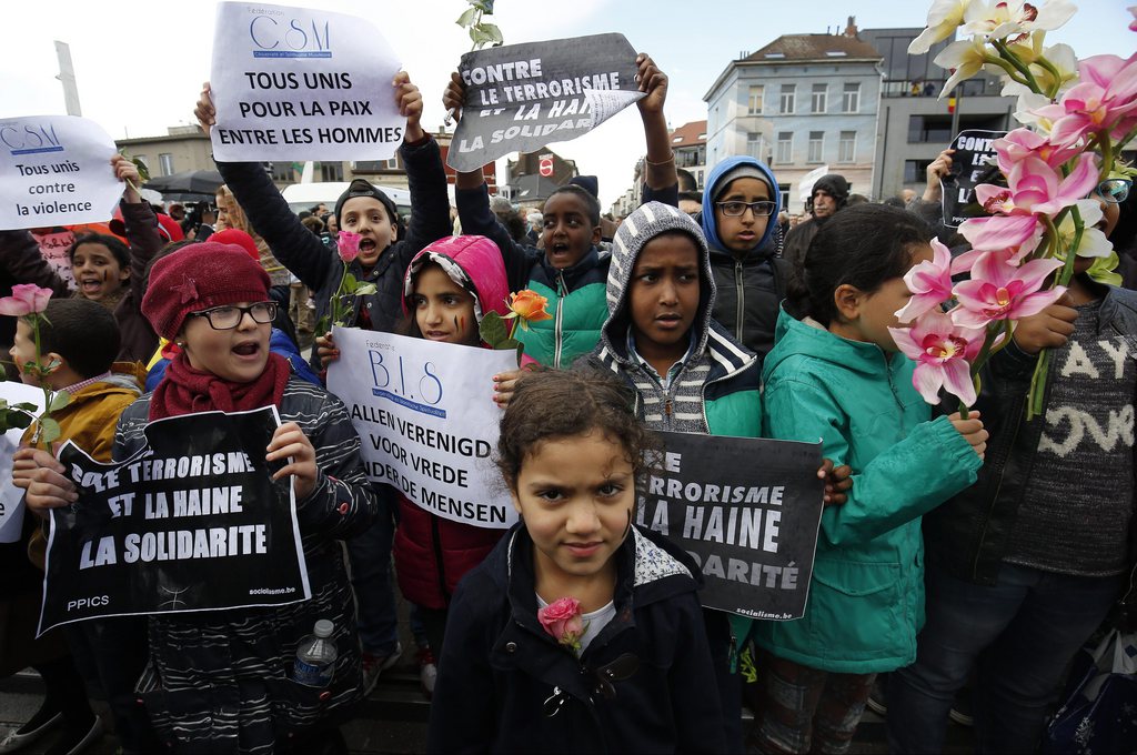 Des enfants du quartier de Molenbeek brandissent des pancartes, à la tête du cortège bruxellois, organisé en hommage aux victimes.