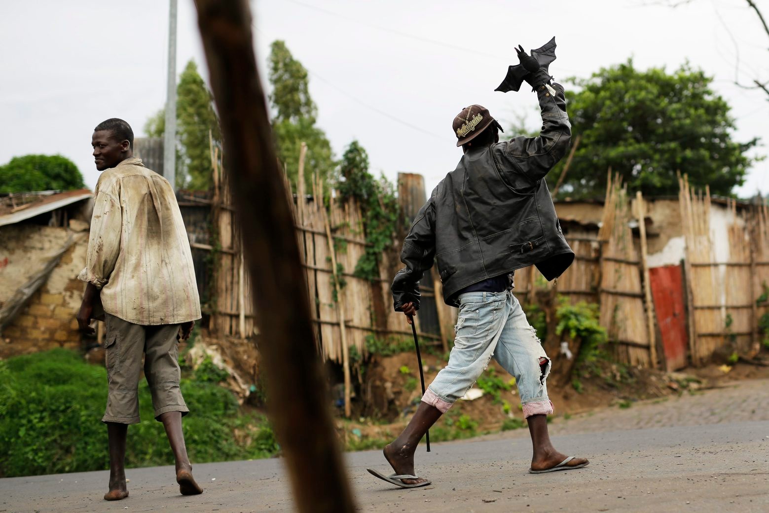 A demonstrator wears a glove in the shape of a bat as he marches up and down the main strip of the Musaga neighborhood of Bujumbura, Burundi, Monday, May 18, 2015. The army has been deployed throughout the town as hundreds return to the streets Monday to protest the president's decision to seek a third term.  ( AP Photo/Jerome Delay)   Burundi Political Tensions