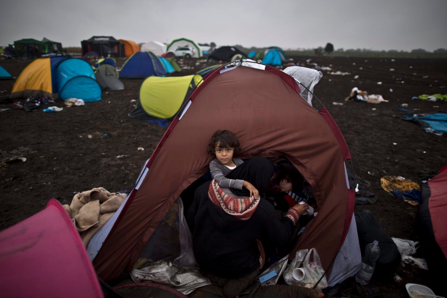 Syrian refugee child Zaid Hussein, 4, is held by his mother while sitting inside their tent at a makeshift camp for asylum seekers in Roszke, southern Hungary, Friday, Sept. 11, 2015. EU officials and human rights groups say they've been disappointed by the animosity toward asylum-seekers in countries from which hundreds of thousands of people fled communist dictatorships just decades ago. (AP Photo/Muhammed Muheisen) Hungary Migrants