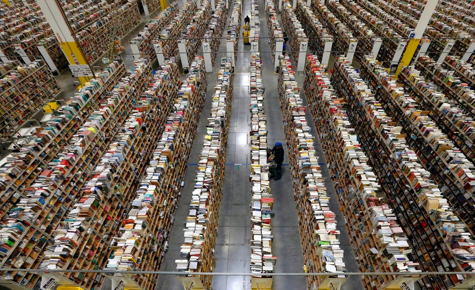 FILE - In this Monday, Dec. 2, 2013, file photo, an Amazon.com employee stocks products along one of the many miles of aisles at an Amazon.com Fulfillment Center in Phoenix. Amazon reports quarterly earnings on Thursday, Jan. 30, 2014. (AP Photo/Ross D. Franklin, File) Earns Amazon
