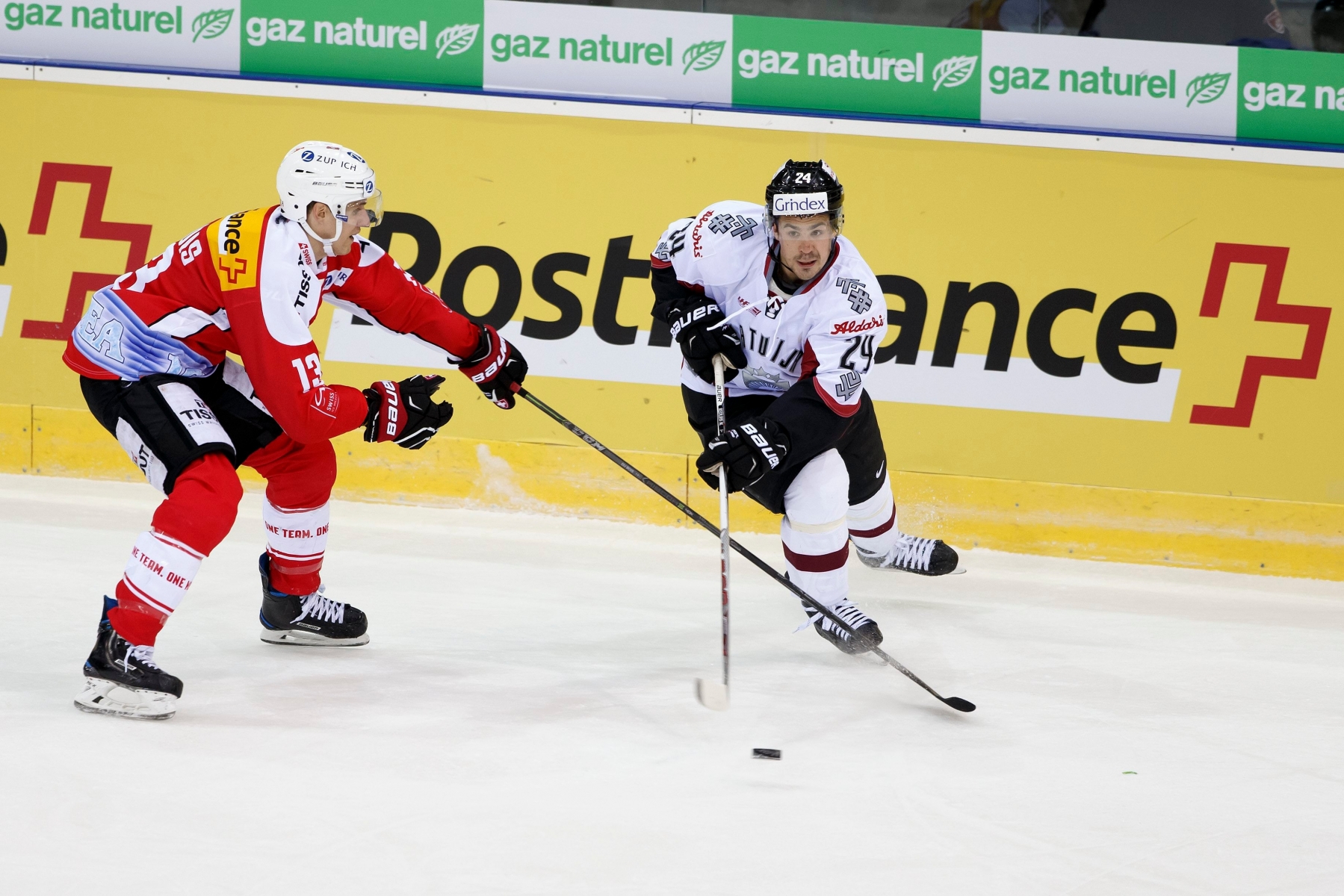 Switzerland's Felicien Du Bois, left, vies for the puck with Latvia's Mikelis Redlihs, right, during friendly ice hockey game between Switzerland and Latvia, at the ice stadium Les Vernets, in Geneva, Switzerland, Friday, April 29, 2016. (PHOTOPRESS/Salvatore Di Nolfi) SWITZERLAND ICE HOCKEY CHE LAT