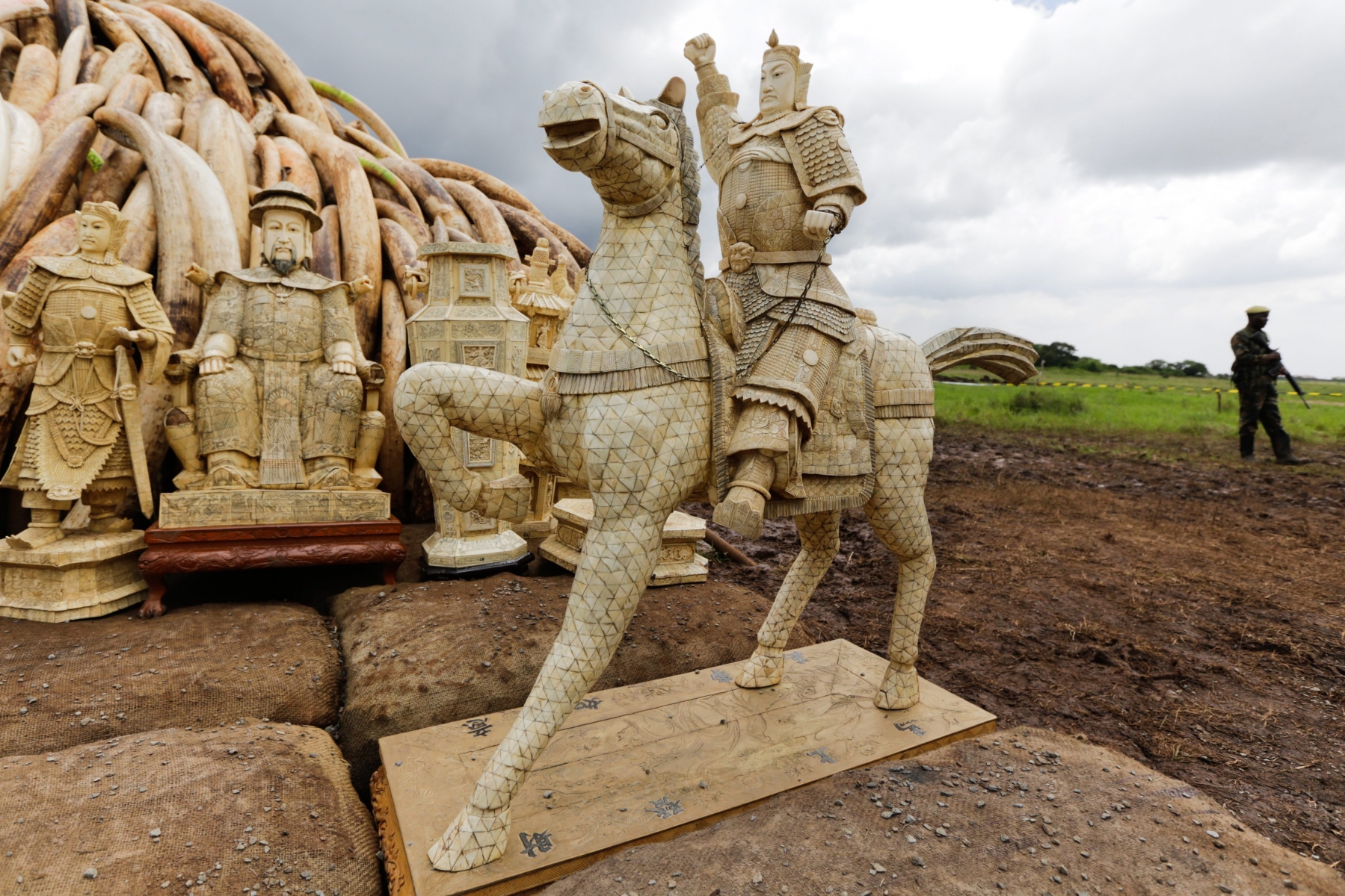 epa05281300 Kenya Wildlife Service (KWS) ranger(R), patrol next to an Ivory statue standing in front of some of the confiscated ivory stockpile stacked up onto pyres, at the Nairobi National Park, in Nairobi, Kenya, 28 April 2016. KWS has stacked up 105 tonnes, of Ivory at a burning site ahead of the ivory burning event on 30 April 2016. This would be the single biggest haul ever to be burn.  EPA/DANIEL IRUNGU KENYA IVORY BURNING