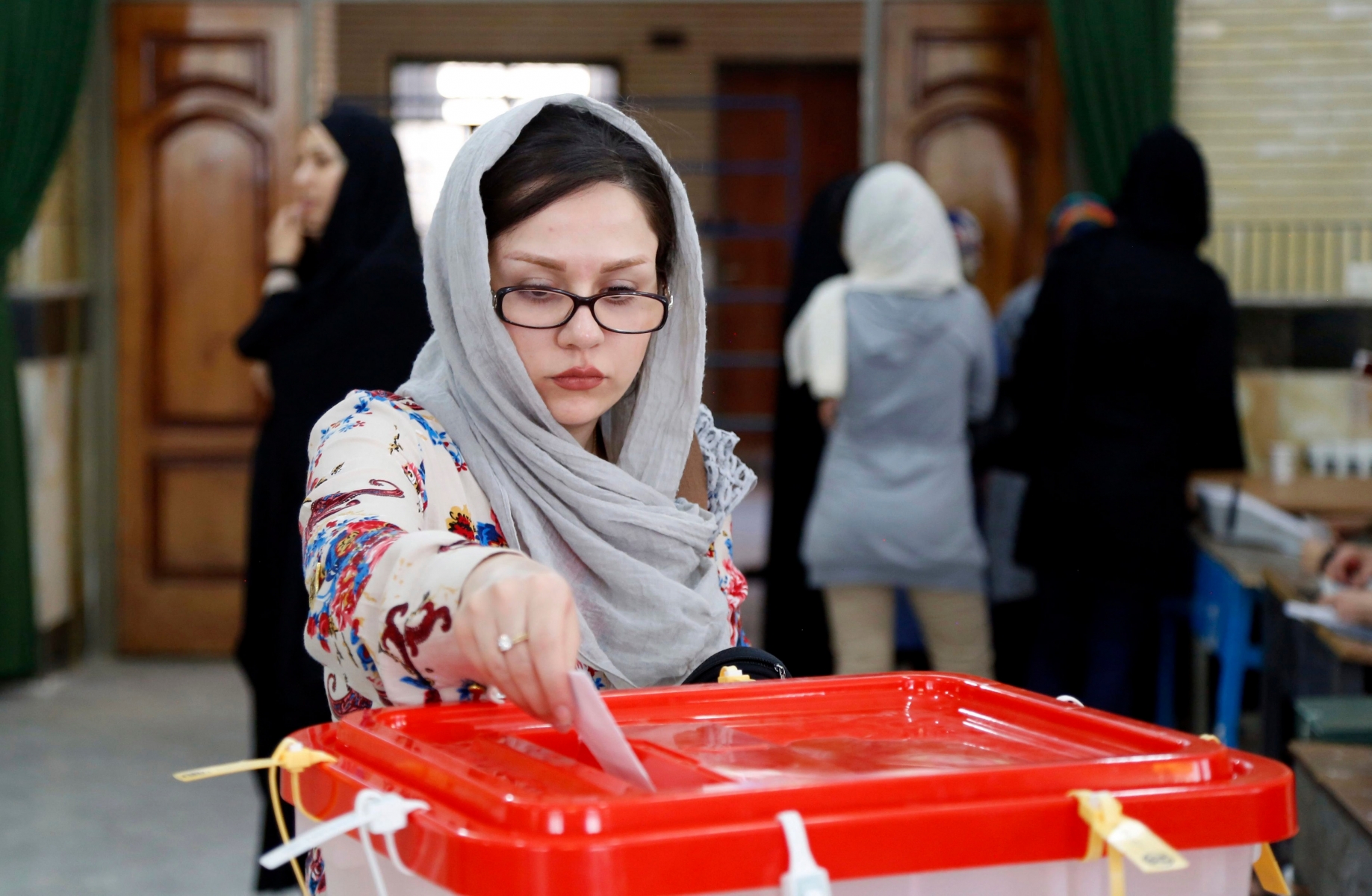 FILE - In this Friday, April 29, 2016 file photo, an Iranian woman casts her ballot for the parliamentary runoff elections in a polling station at the city of Qods about 12 miles (20 kilometers) west of the capital Tehran, Iran. Iranian state TV says that the moderate-reformist bloc has secured more than 20 more seats in parliamentary runoff elections, bringing the bloc closer to a majority in the next legislature. State TV on Saturday, April 30, announced winners for 45 of the remaining 68 seats being contested. (AP Photo, File) Iran